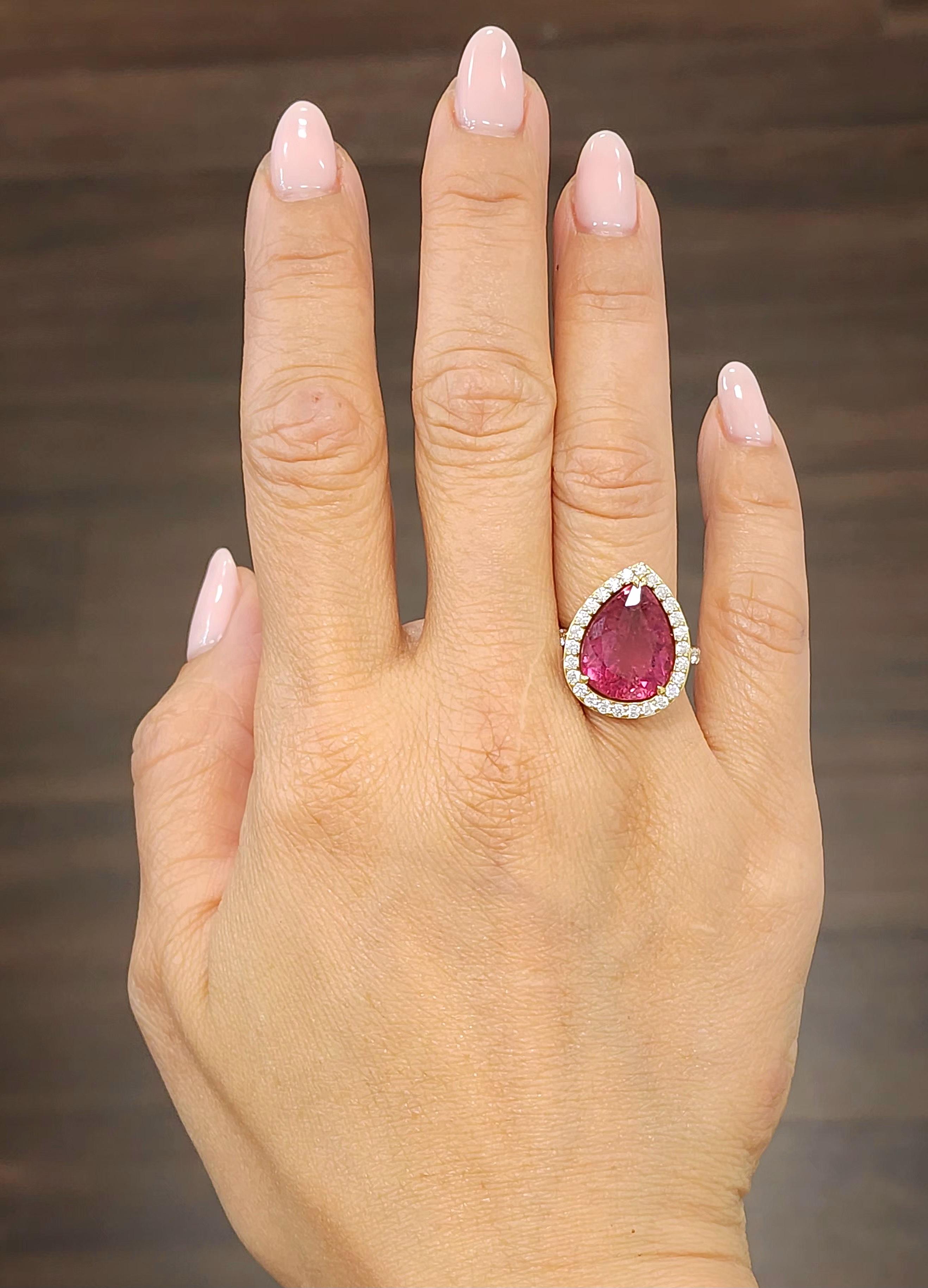 This gorgeous natural rubellite and diamond ring features one pear shape natural rubellite weighing 6.90 ct and has a redish/pinkish hue. The ring also has 38 round brilliant cut diamonds weighing 0.85 ct and graded E-F in color and VS1 in