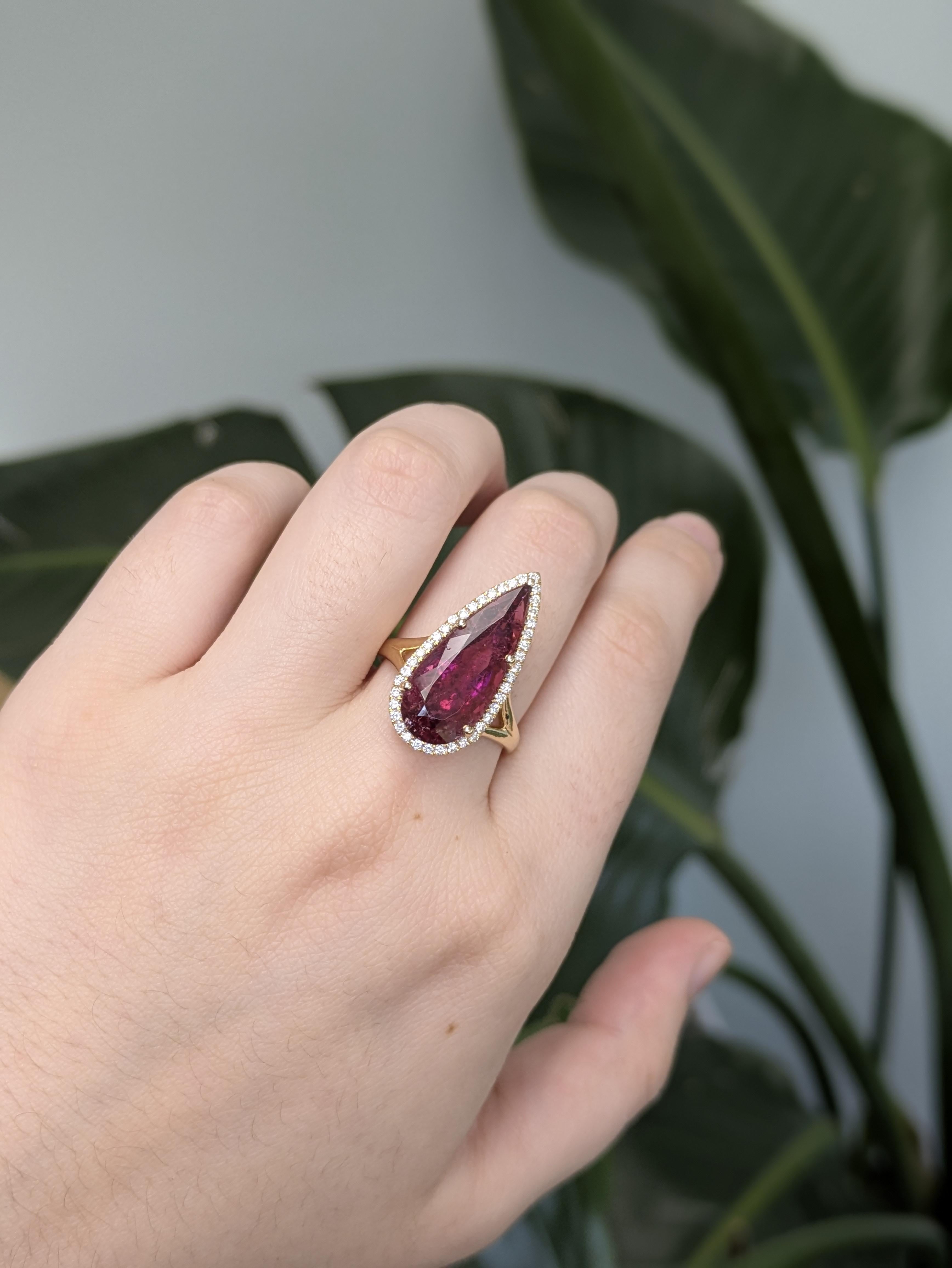 This stunning ring features a vivid 7.76-carat pear-shaped Rubellite Tourmaline, untreated and sourced from Brazil. Set in 14k gold (3.854g), the vibrant center stone is accented by 41 sparkling diamonds totaling 0.32 carats. A sophisticated and