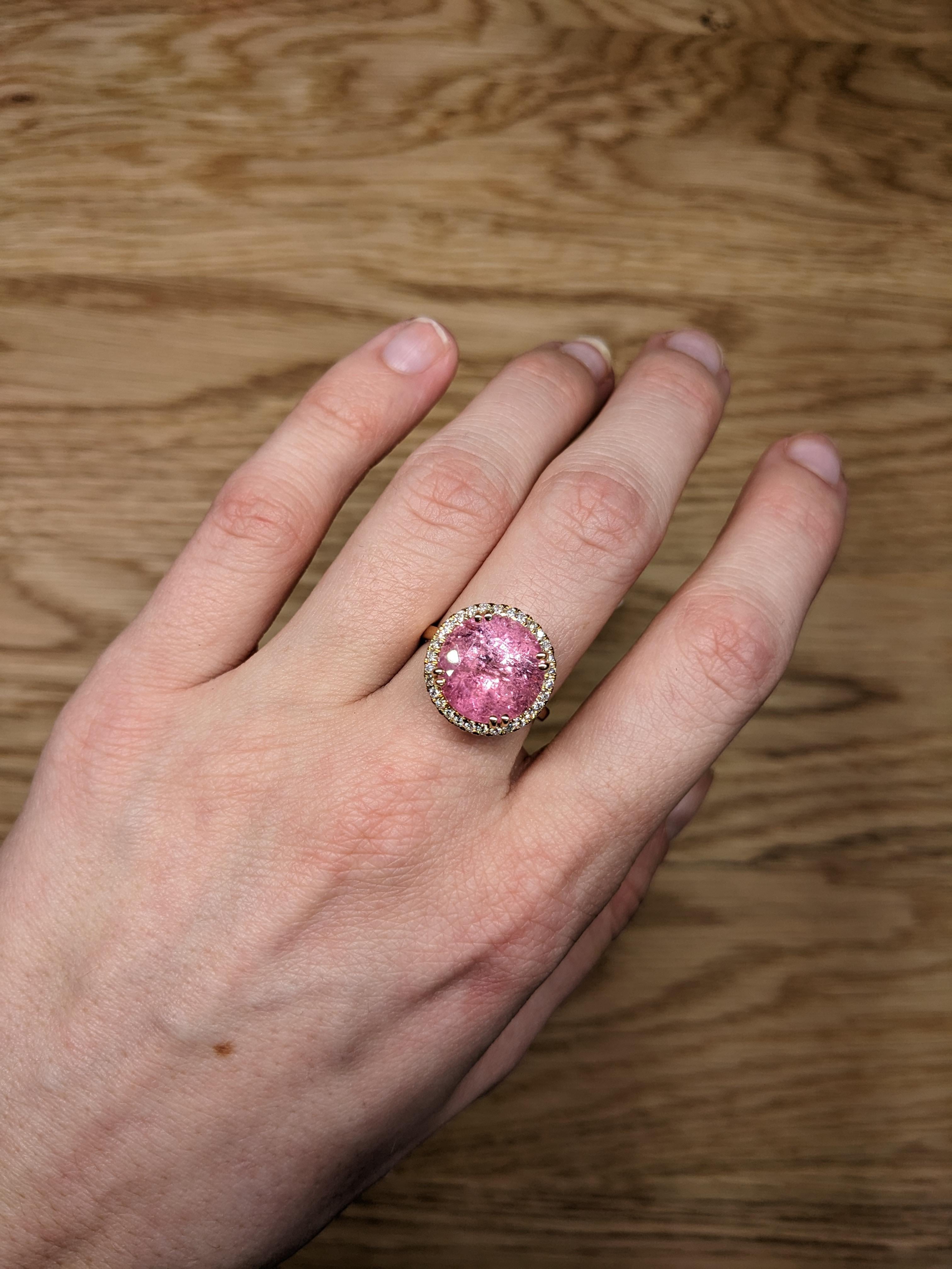 A stunning and captivating piece, radiating beauty and elegance. At its heart lies a remarkable 7.77-carat pink tourmaline, cut into a perfect round shape (12.8mm), exuding a soft yet vibrant pink hue that immediately catches the eye. This exquisite