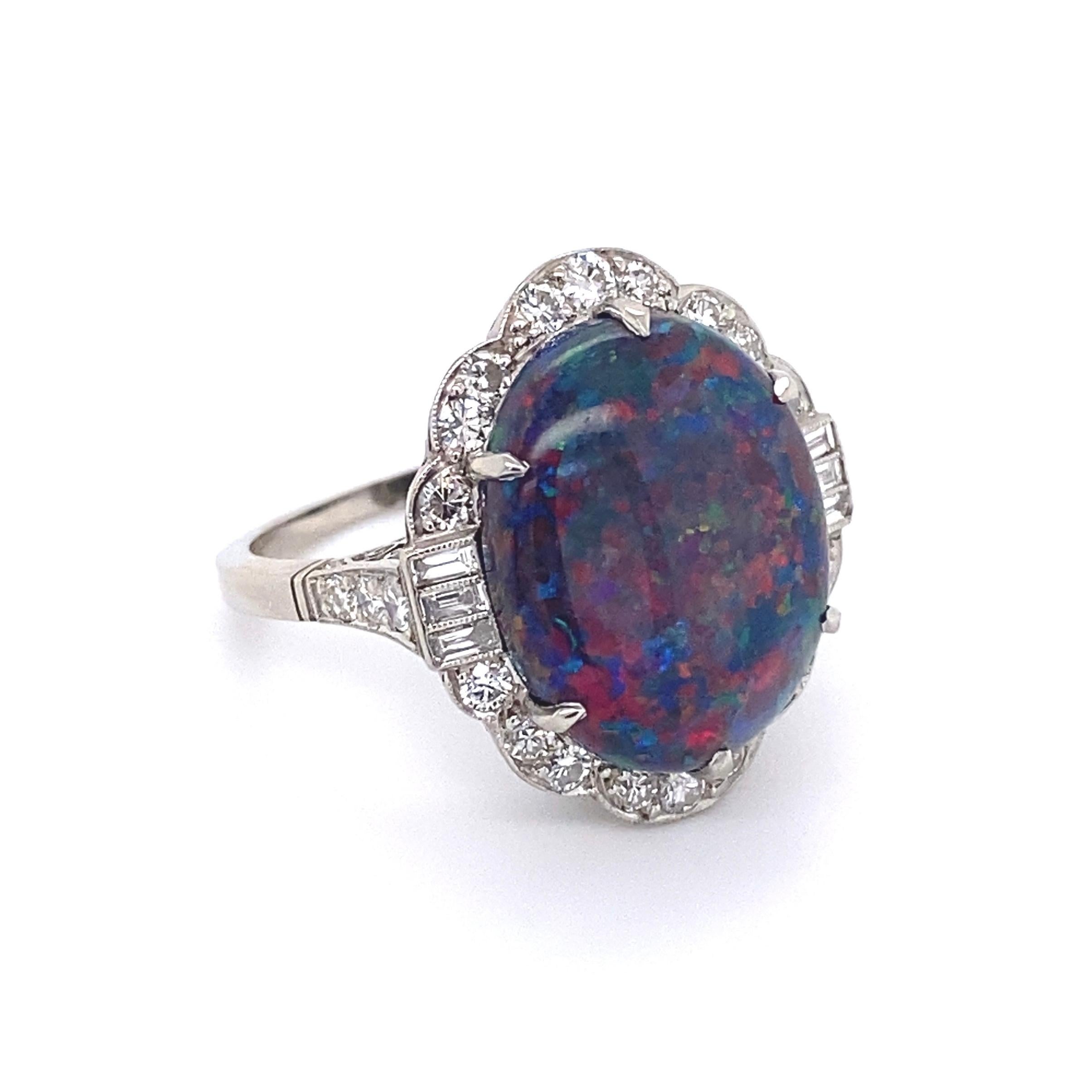 Simply Beautiful!  Finely detailed Black Opal and Diamond Cocktail Ring. Centering a securely nestled Hand set 7.78 Carat Oval Symmetrical Australian Lightning Ridge Black Opal surrounded by Old Round-Cut and Baguette Diamonds, weighing approx.