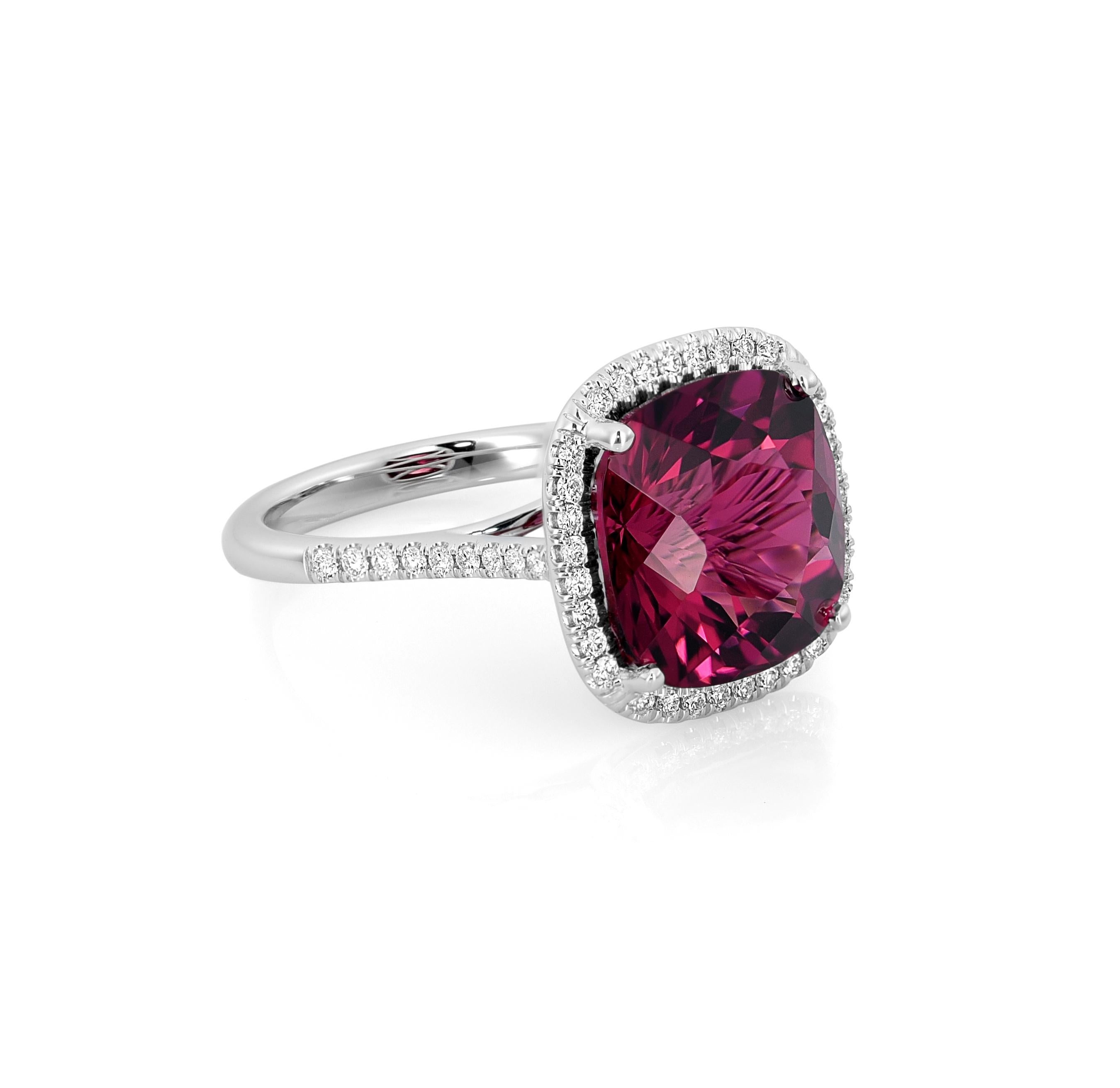 The jewelry piece features a stunning cushion-shaped Natural Red Tourmaline gemstone, measuring 12 x 12.10 x 8.77 mm and weighing 7.78 carats. It is elegantly set in 14K White Gold. The intricate design includes 0.31 carats of dazzling diamonds as