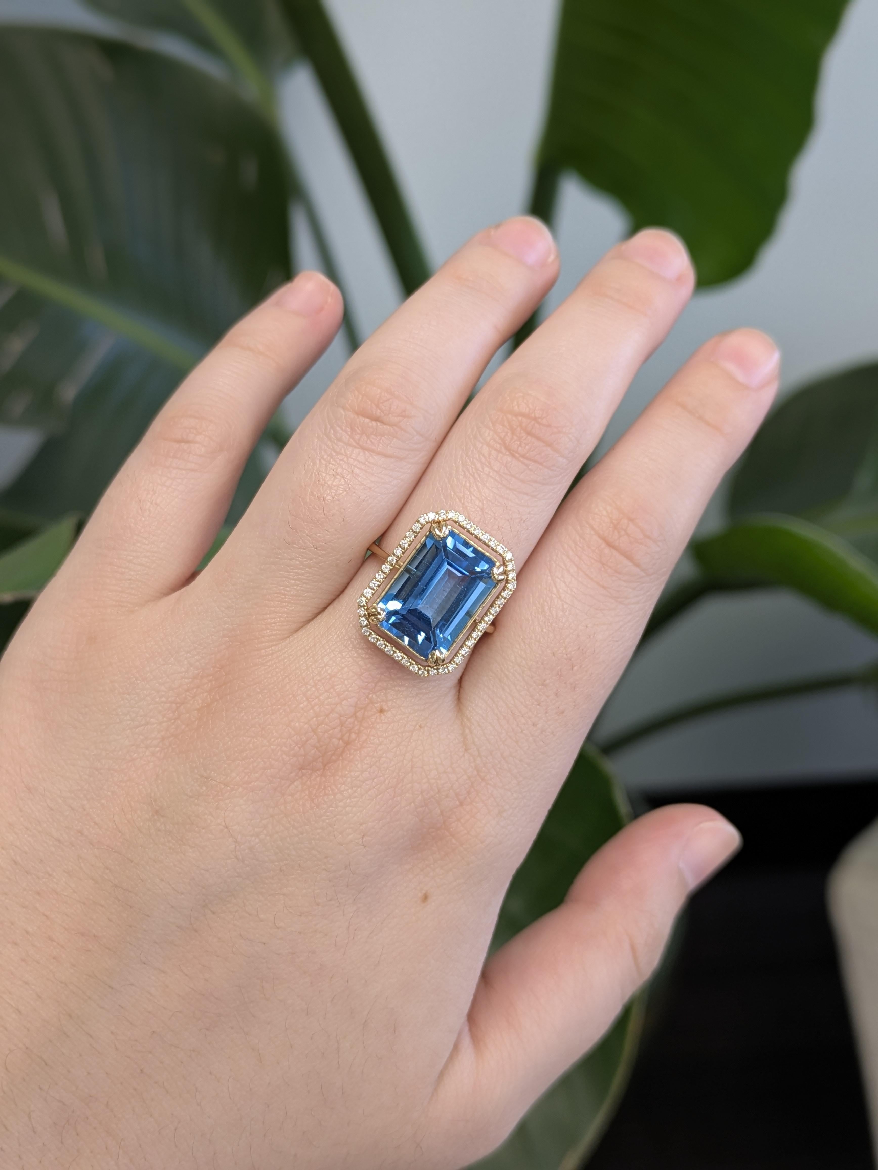 Fai una dichiarazione audace con questo squisito anello con Topazio Svizzero, caratterizzato da una pietra centrale con taglio a smeraldo in una vibrante tonalità blu cielo. Incorniciato da un'aureola di diamanti tondi naturali, il centrotavola