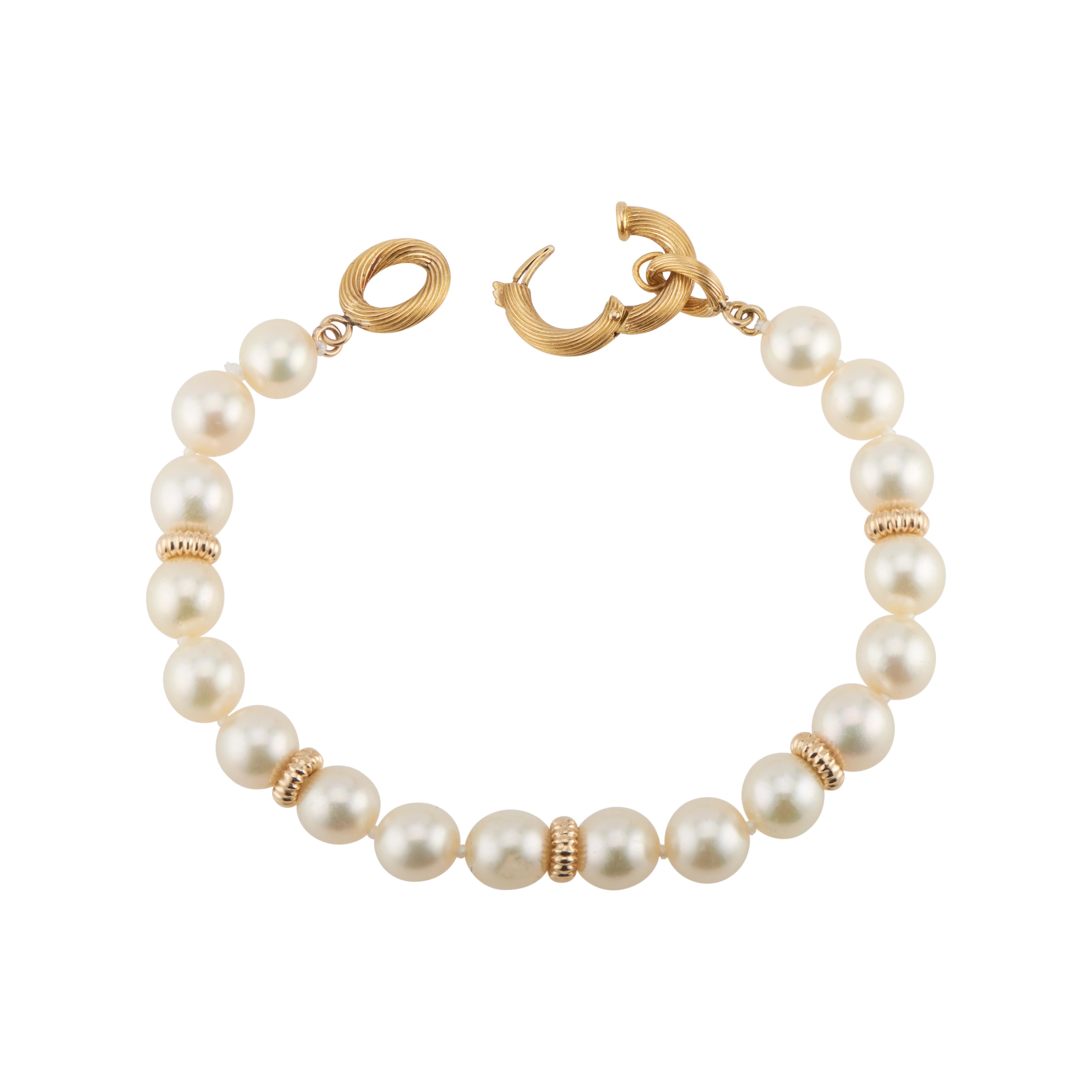 1970's Lustrous 7.75mm cultured pearl bracelet with 14k gold catch and bead spacers. 7 inches long. 

18 cultured crème hue pearls, pink overtone, few blemishes and good lustre 7.75mm
16k-22k yellow gold 
14.7 grams
Bracelet: 7 Inches
Width: