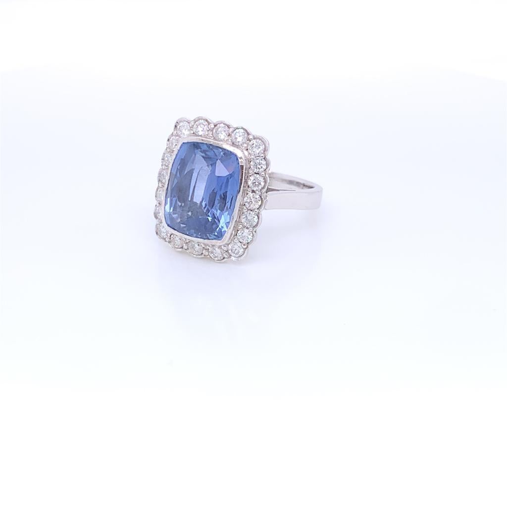 This expertly handcrafted ring features a sparkling, cushion cut Blue Sapphire at its centre. This magnificent stone weighs approximately 7.80 carats and is set in a spectacular frame of Round Brilliant Diamonds weighing a total of 0.71 carats. This