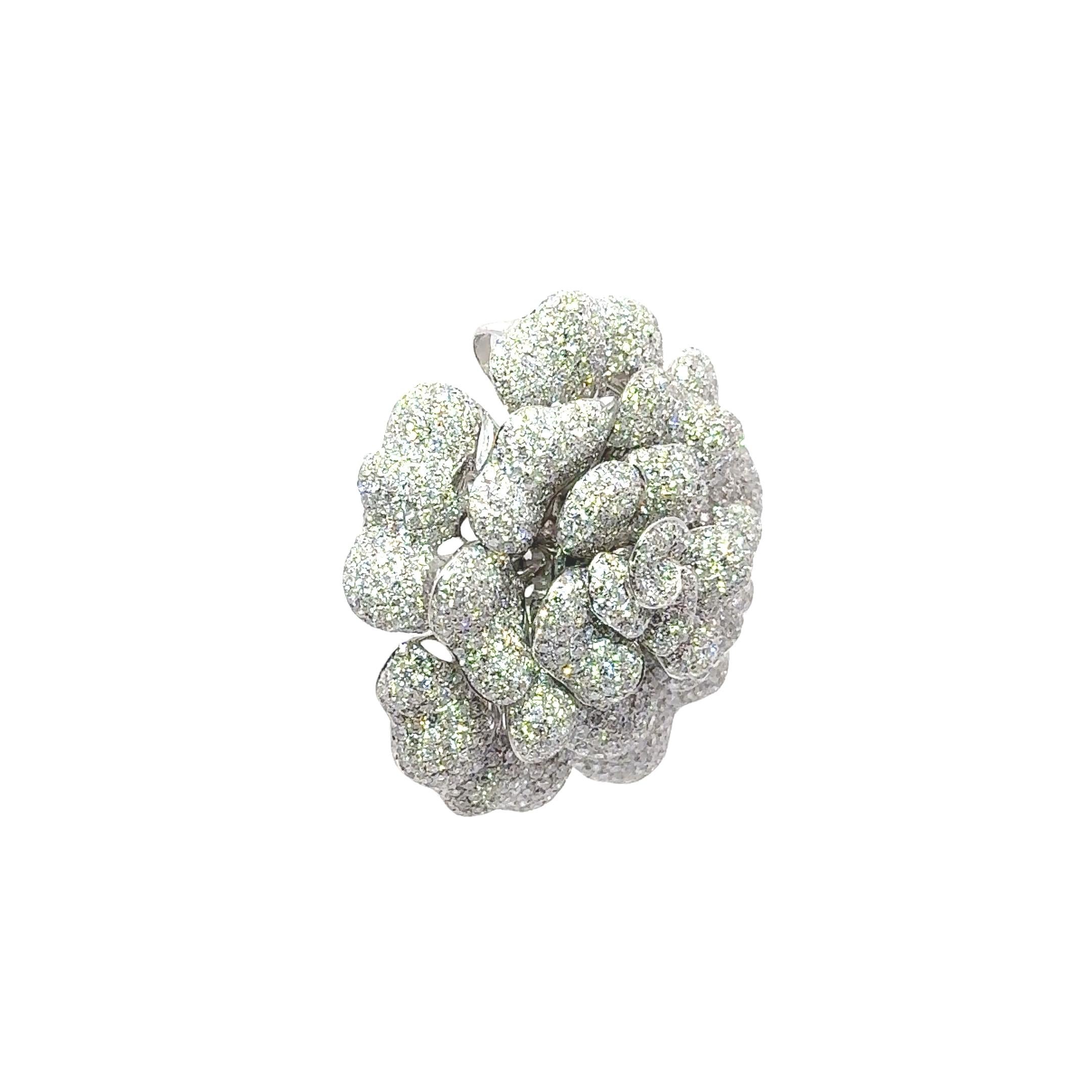 A contemporary 3-dimensional brooch featuring approximately 7.80 carats of round brilliant-cut white diamonds. They are VS in clarity and G-H in color making them shine brightly with immense brilliance and sparkle. The intricate floral design