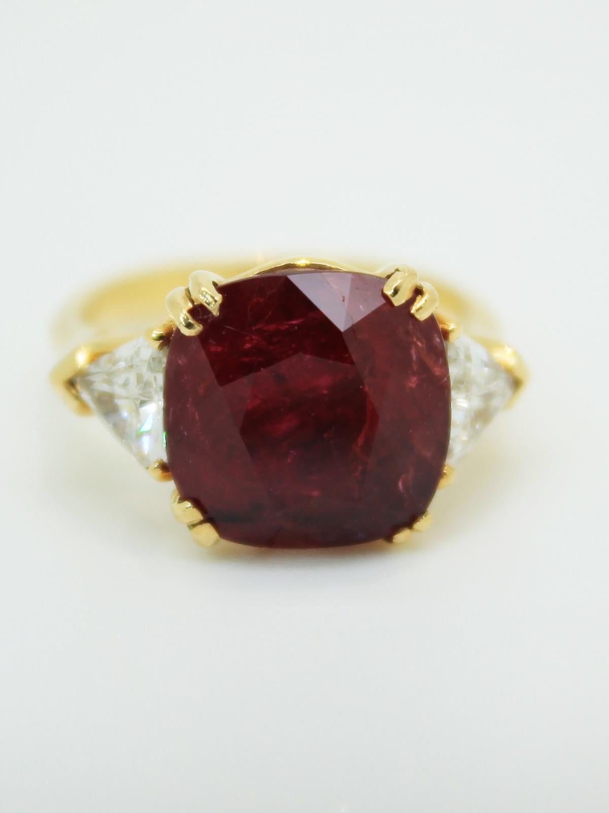 A bespoke and impressive three stone ruby and diamond ring, set in 18 karat gold. The ruby measures 7.83 carats and has been certified by C. Dunaigre Consulting an independent and experienced gemstone expert based in Switzerland.

The ruby report
