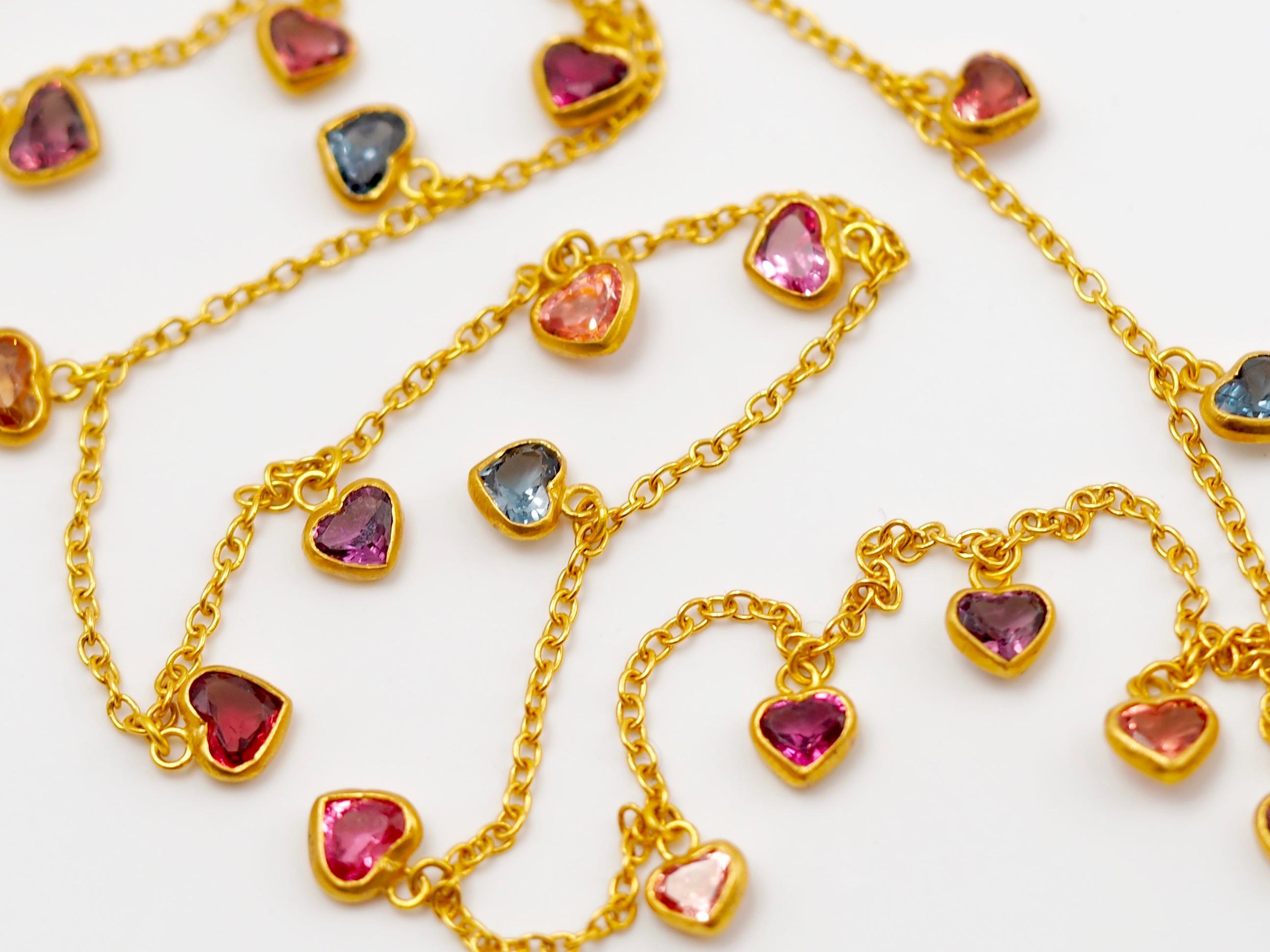 This bright necklace by Scrives is composed of 21 natural multicolour spinels (total spinels weight: 7.85cts, origin: Myanmar) in heart shape set in gold pending from a gold chain. Hearths are all different, in colour and in size/shape. They have