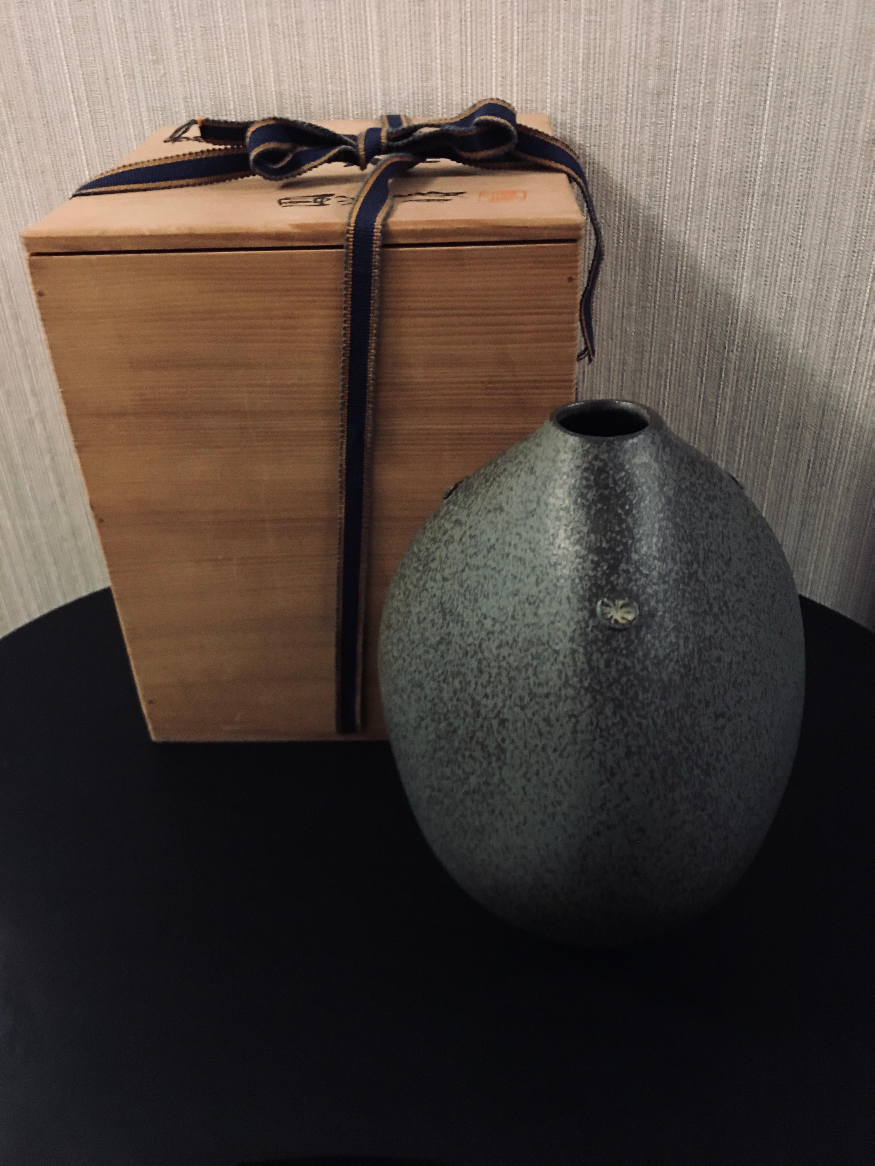 786 Japanese Kiyomizu-ware. Emperor Showa from 1926 to 1989 – 1990. Ca. 1970. 9” high x 6 ½” wide. Fine condition. Signed, features a fine gray glaze with flex of black glaze ,vase of dramatic oval form with mon accents signed box Kiyomizu ware