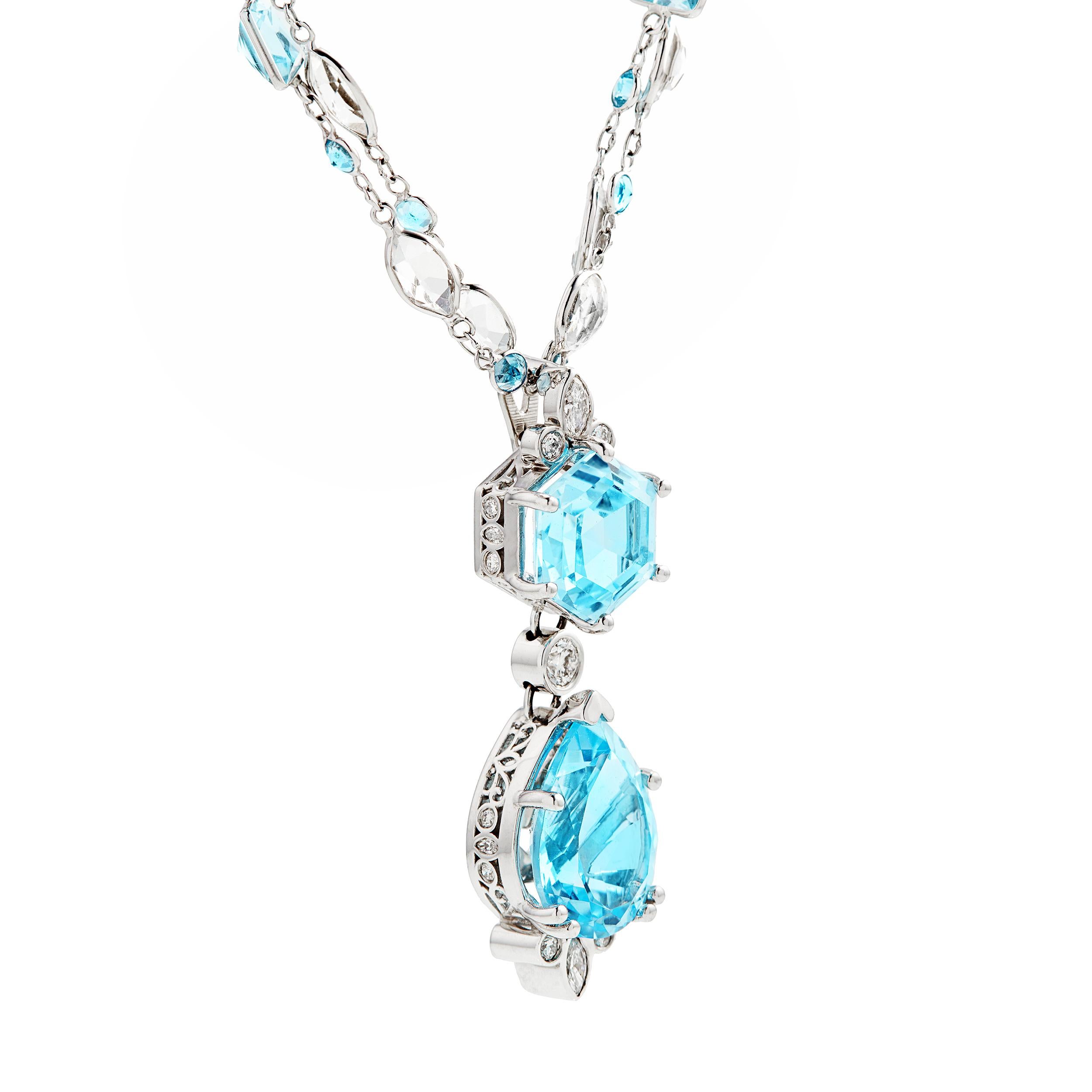 This necklace invokes the color of a bright clear blue sky. It's cheerful and beautiful with Fancy-shaped Blue Topaz throughout this one of a kind design. Notice the detail in the side of the pendant mounting, which also features an enhancer to