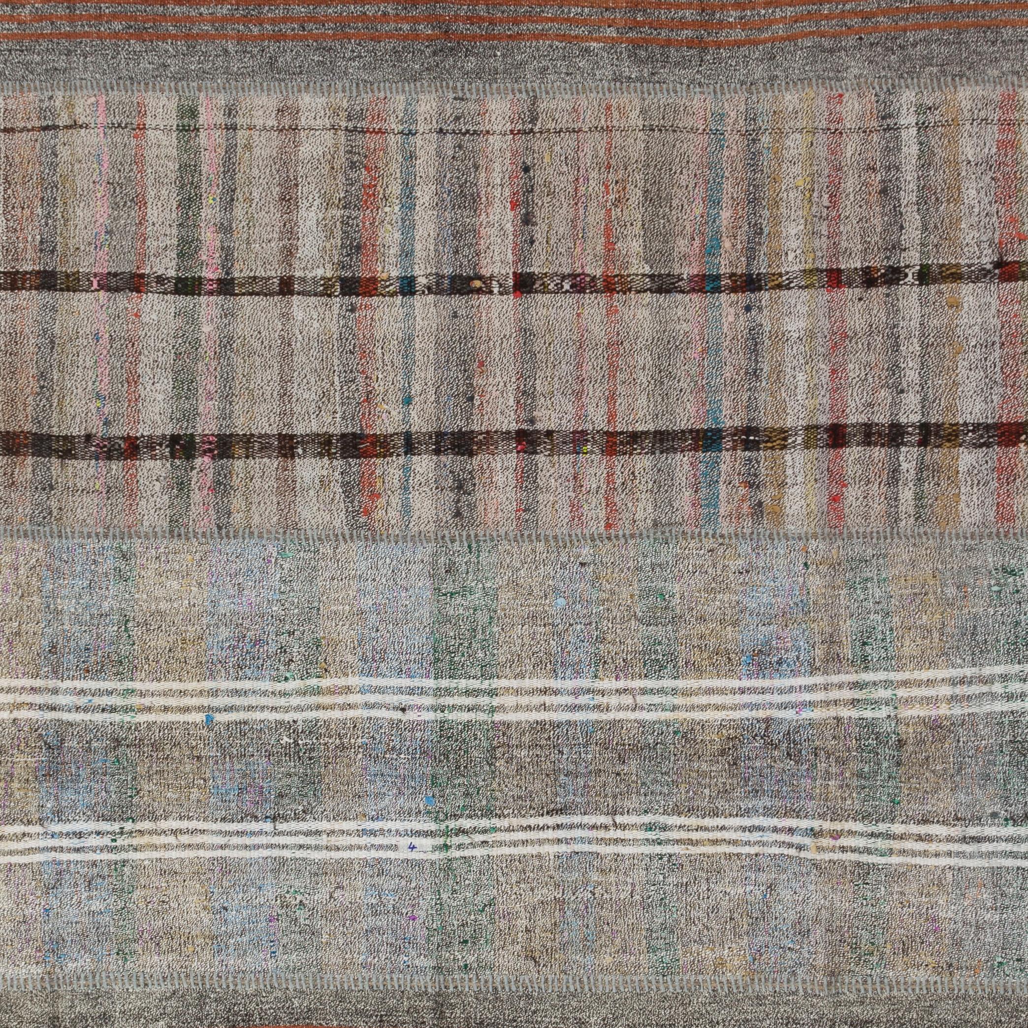 A vintage hand-woven Turkish nomadic patchwork kilim/flat-weave, made up hand-stitched pieces. This sturdy and lightweight floor covering was woven with cotton and goat hair and features stripes against a speckled looking background in soft neutral