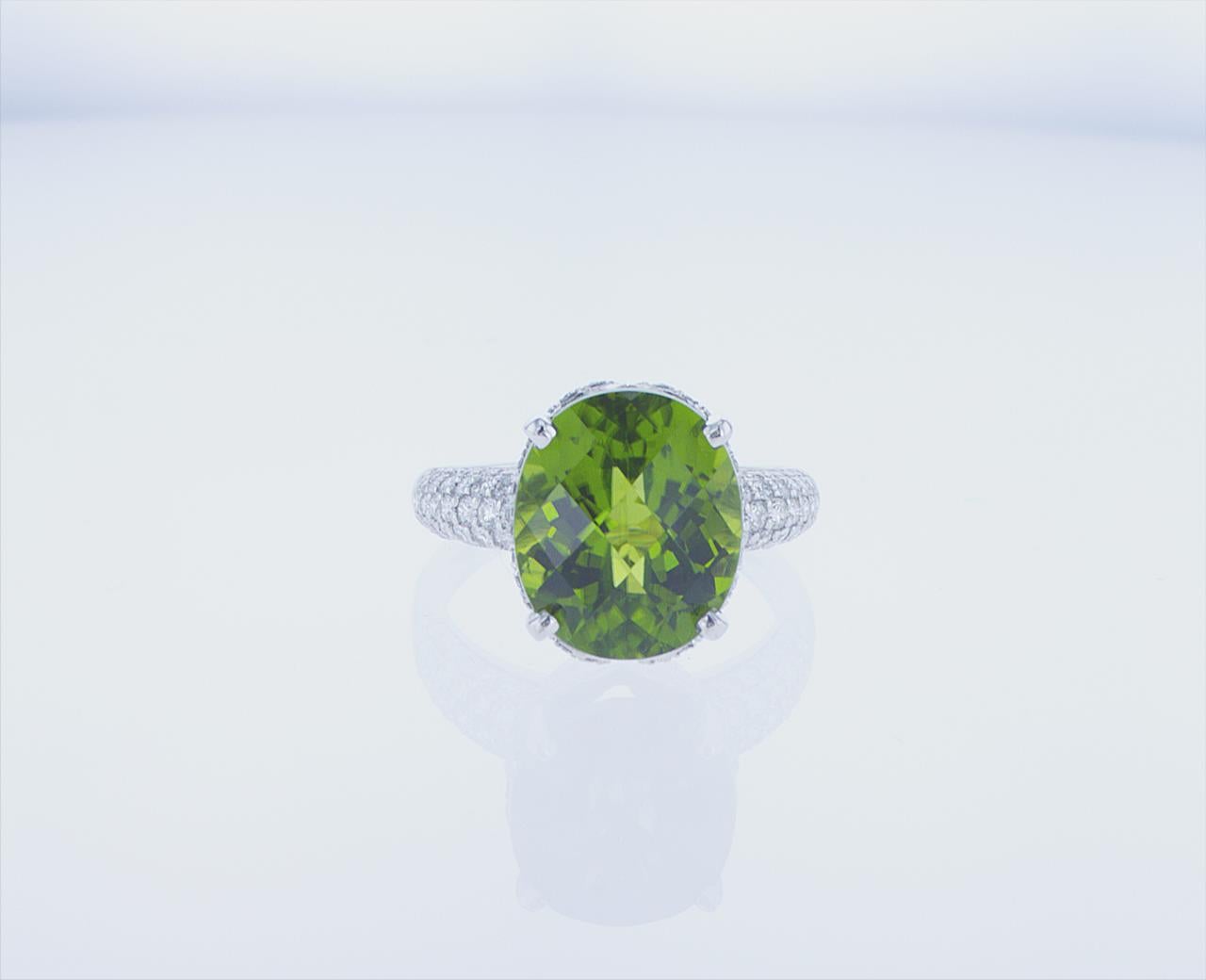 7.93 Carat Oval Peridot cocktail ring. 0.88 Carats total weight of G/H Color, VS Clarity Roud Brilliant Diamonds. 18k White Gold with Palladium mounting.