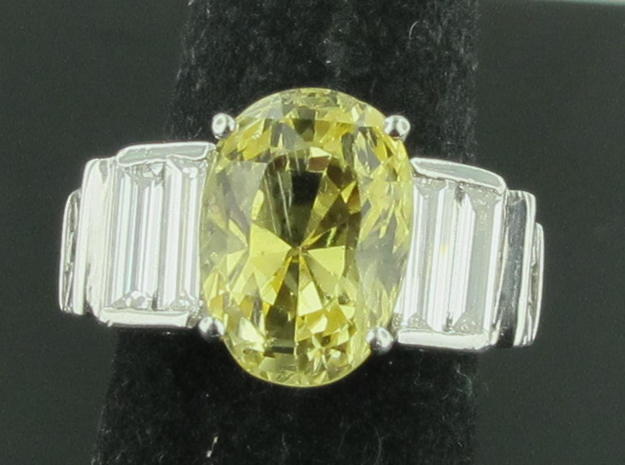 Fancy Yellow Cut Sapphire weighing 7.94 carats set in Platinum with 10 baguette diamonds on the sides with a total weight of 3.0 carats.  Platinum weight is 14 grams.  Ring is size 6.