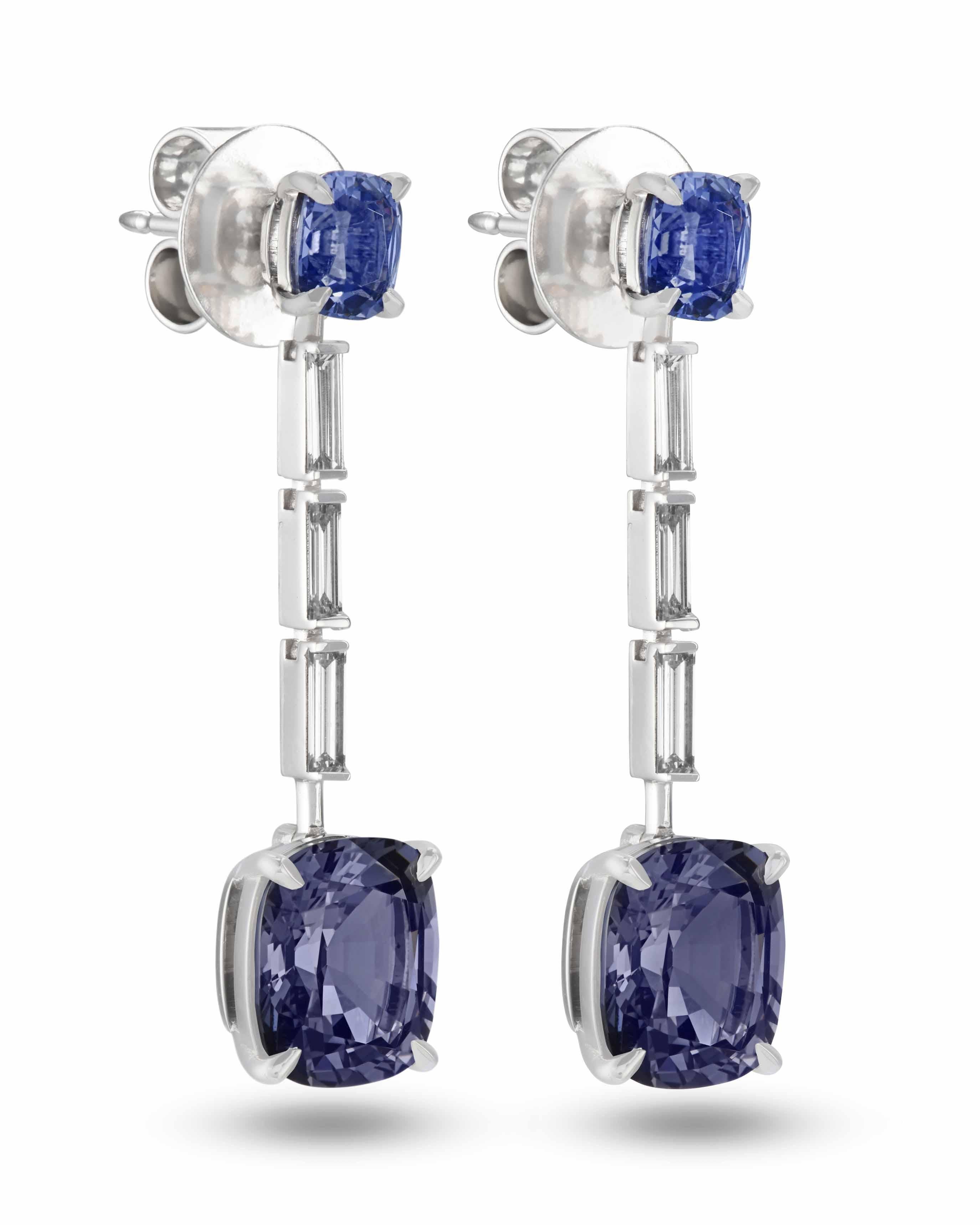 Elegant drop earrings with Burmese spinels and diamonds. This pair is perfect for everyday wear as well as special occasions. Each earring contains a cushion-cut blue-gray spinel followed by three F VS diamond baguettes and a larger grey-violet