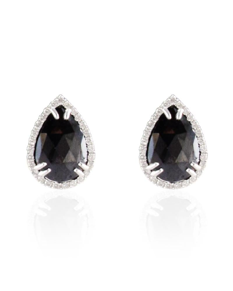 Edgy, elegant, and just your style. The play of white and black seen in these stylish earrings feature a perfectly matched 7.97 carats of pear shaped black diamonds. It is decoratively double-prong set and framed by a halo of 0.58 carats of