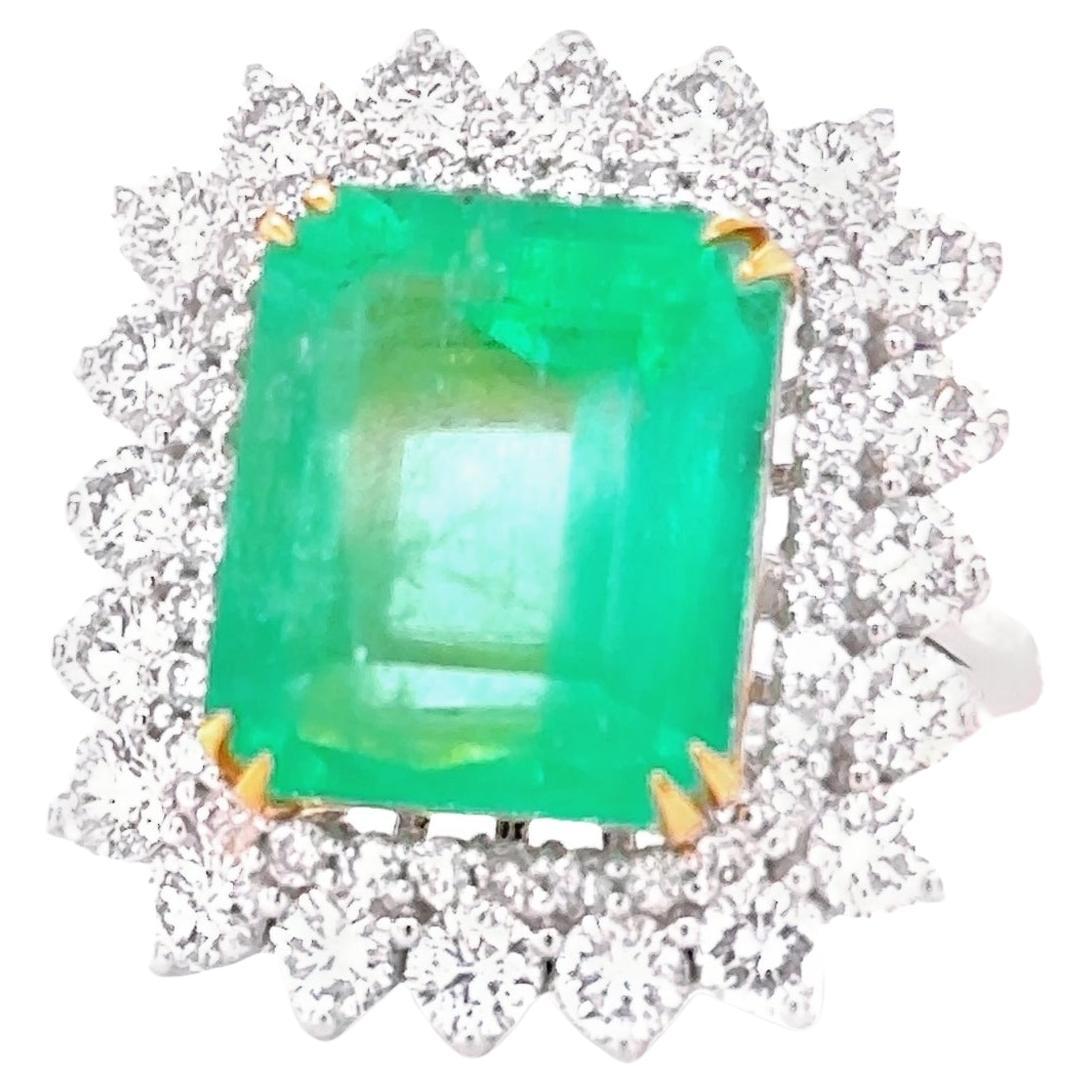A very beautiful and impressive 18 kt White Gold ring set with a natural Vivid Colombian Emerald 7.98 carats circa of great quality, surrounded by 52 Sparkling Round brilliant cut diamonds on the sides,
 total weight 2.14 carats, graded G colour