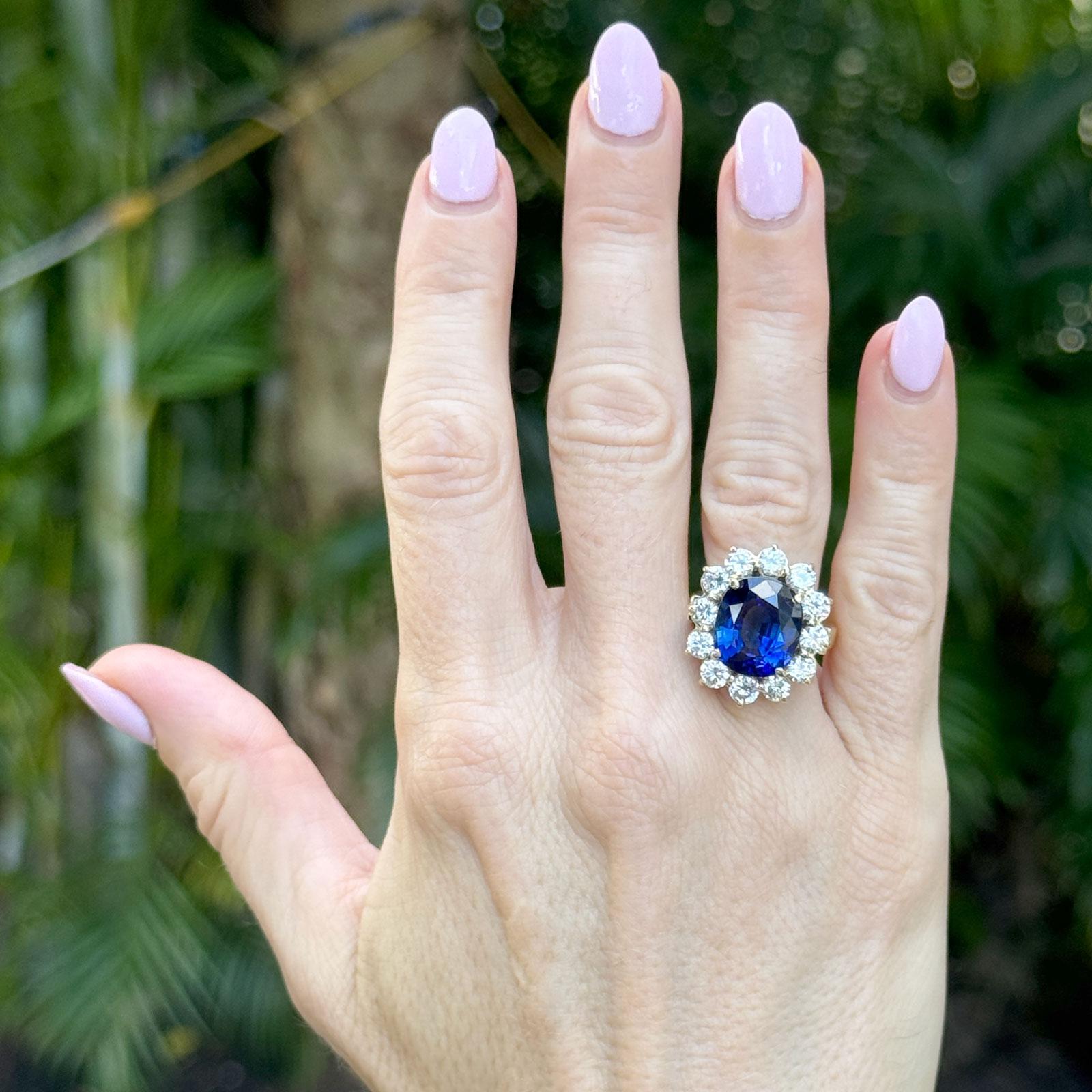 Questo splendido anello con zaffiro e diamante in oro giallo 18 carati mette in mostra un magnifico zaffiro ovale di 7,99 carati di origine malgascia, trattato termicamente e certificato da AGL (Report #1149801). Il ricco centro blu è splendidamente