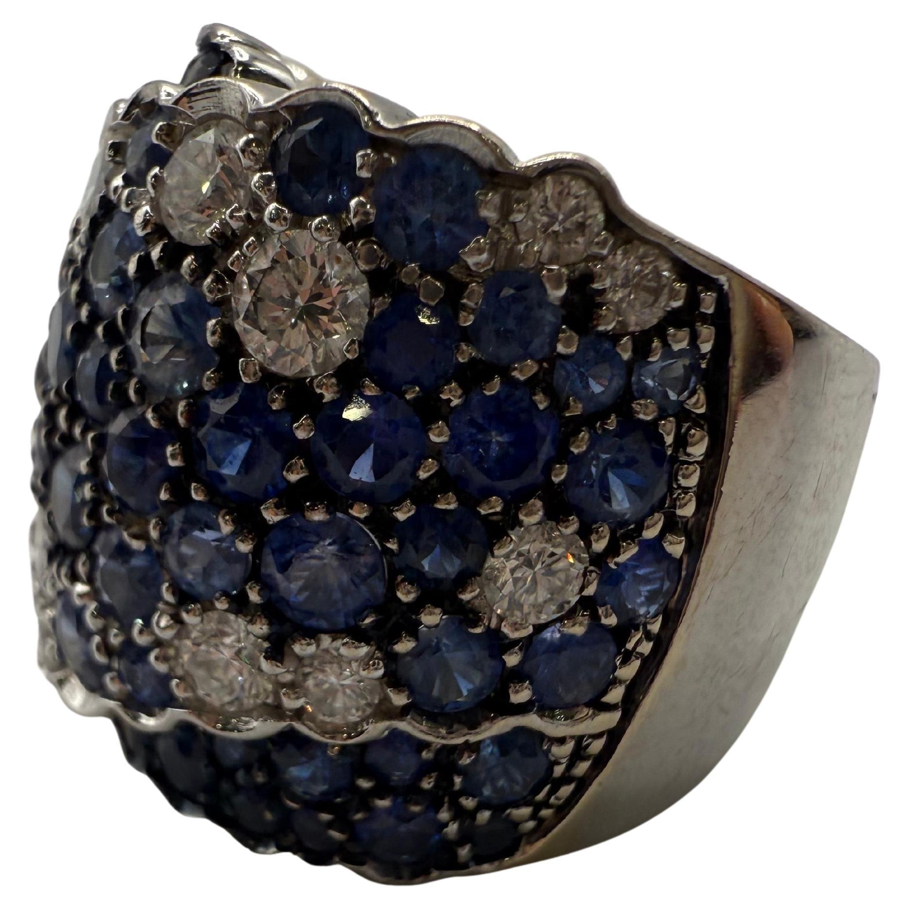 Großer Cocktailring mit Diamanten und Saphiren aus 18 Karat Weißgold. Die Saphire haben insgesamt 5 Karat und die Diamanten insgesamt 2 Karat. Größe 6 (kann geändert werden)
Saphire sind natürlich (leicht eingeschlossen) und Diamanten sind VS-SI