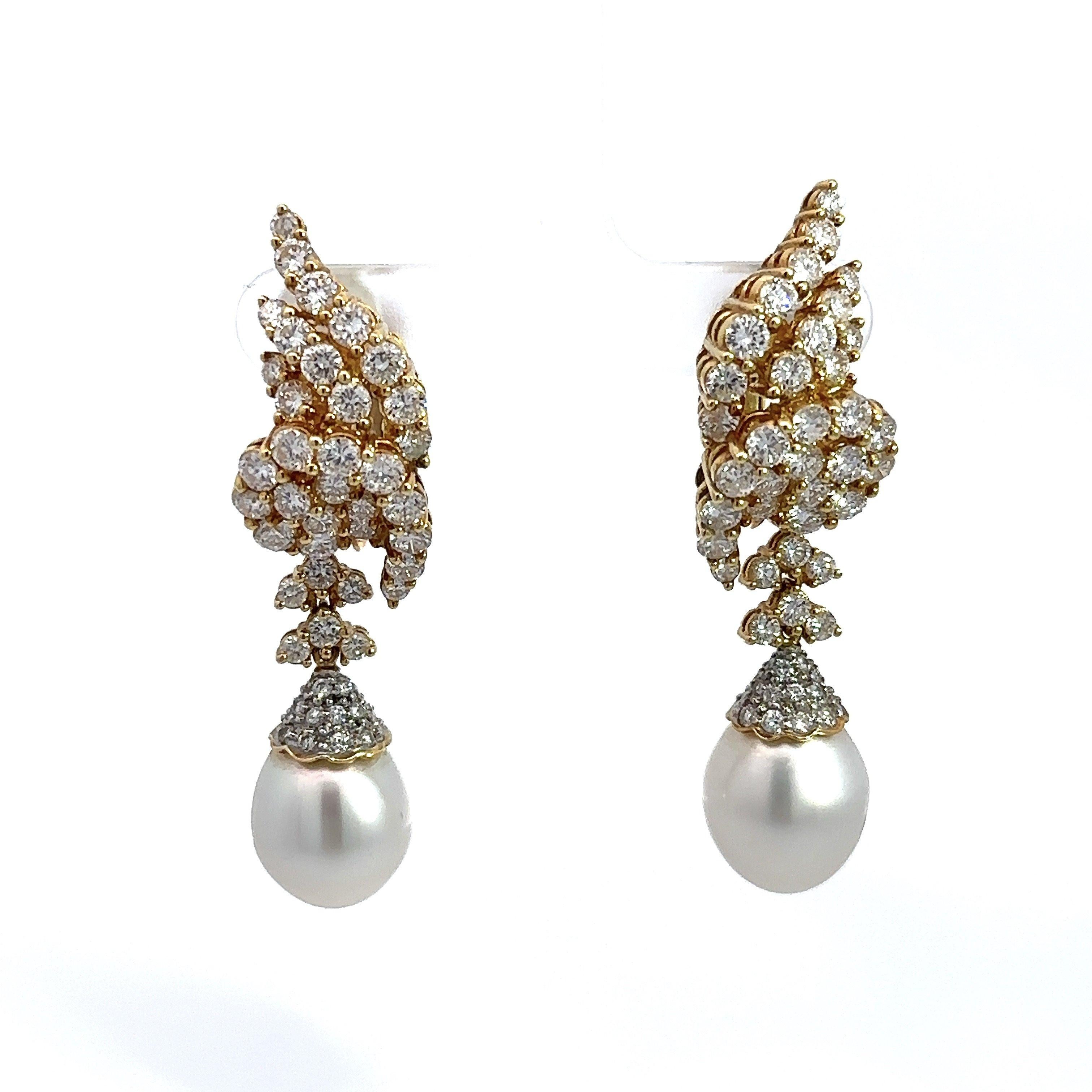These south sea pearl dangle earrings are crafted in 18KT yellow gold and are adorned with 7CT of sparkling diamonds, F-G Color, VS Clarity. The total length of the earring is approximately 2