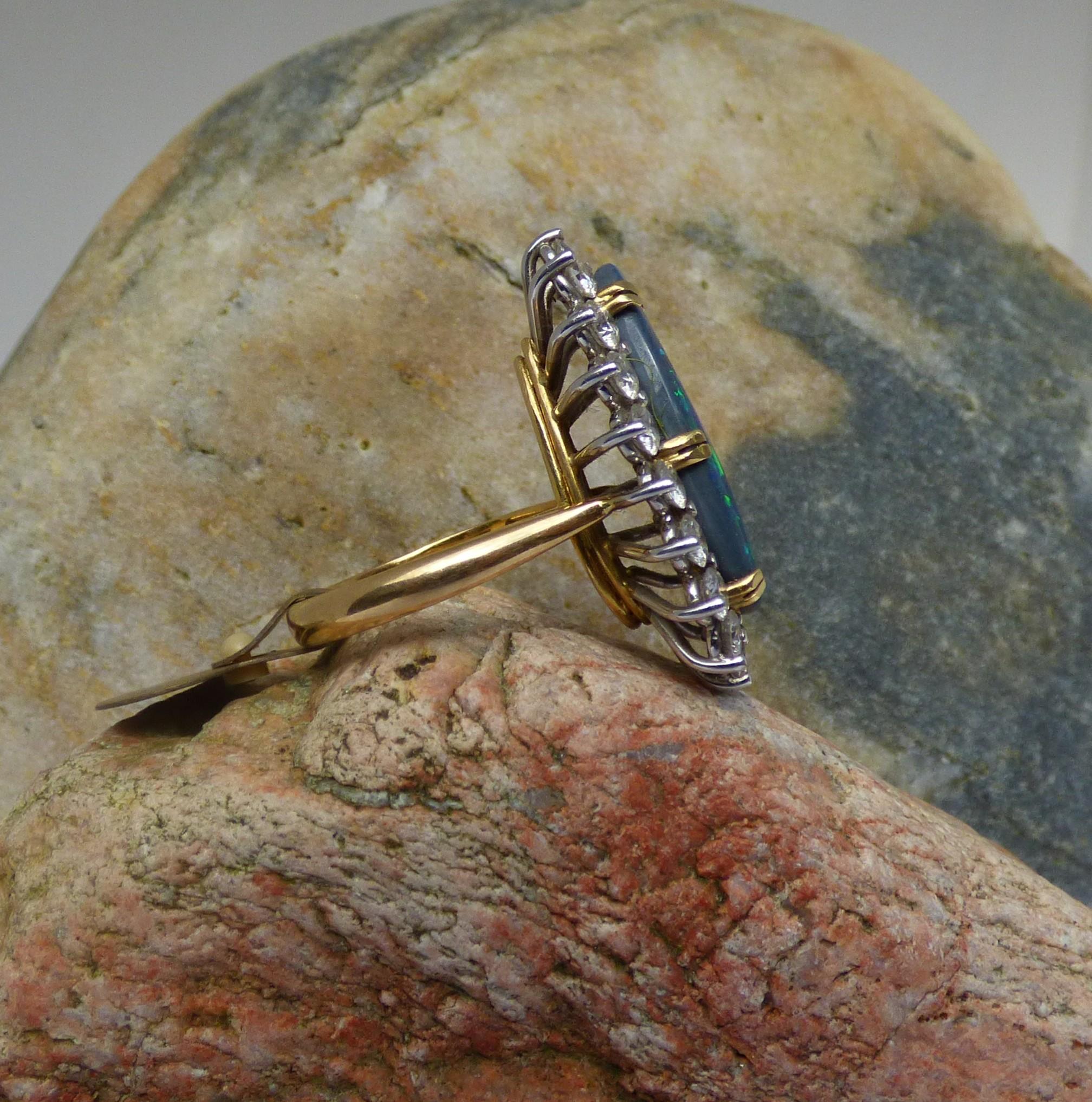 Ein bunter Schwarzer Opal in Birnenform ist 7ct. (22.5X11mm)  Der Opal ist von 19 Diamanten mit einem Gesamtgewicht von 2,03ct umgeben. Der Ring ist aus 18 Karat Gelbgold handgefertigt, die Diamanten sind in Weißgold gefasst.  Der Ring ist vom