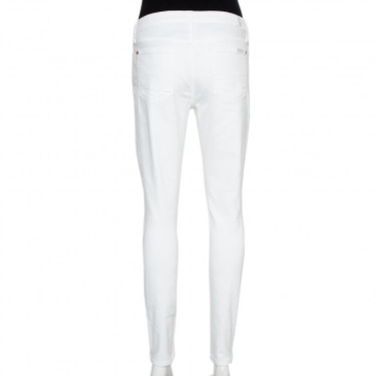 These skinny ankle-length jeans from 7forallmankind are simply fabulous! The white denim pair flaunts distressed knee details and comes equipped with belt loops, a buttoned closure, and five pockets. It will look great with simple T-shirts and