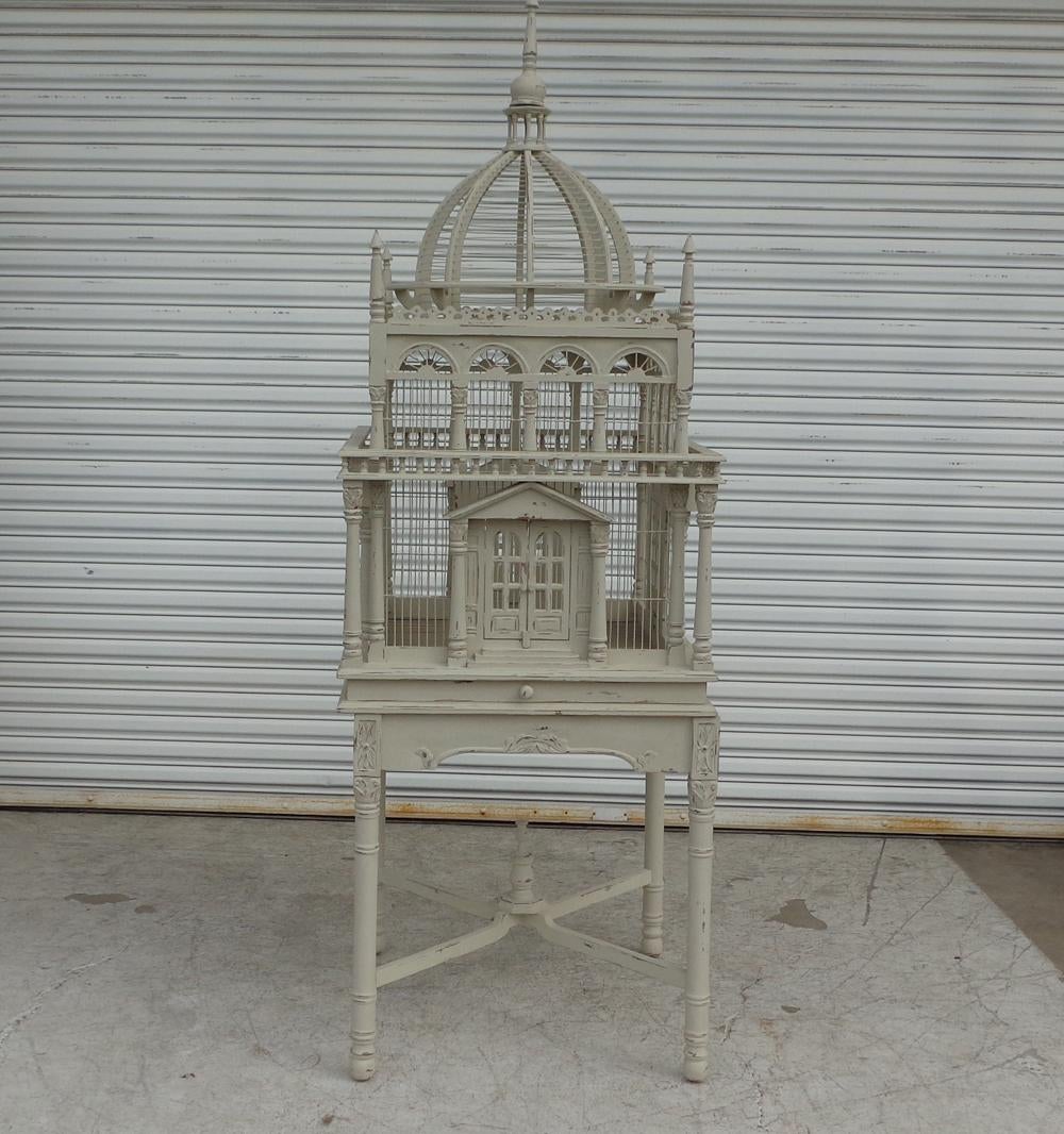 French neoclassical style domed birdcage on pedestal

7FT French neoclassical styled bird cage on pedestal. This grand cage features a wood frame with intricate details including columned doors. The stand is supported by a carved X-base.