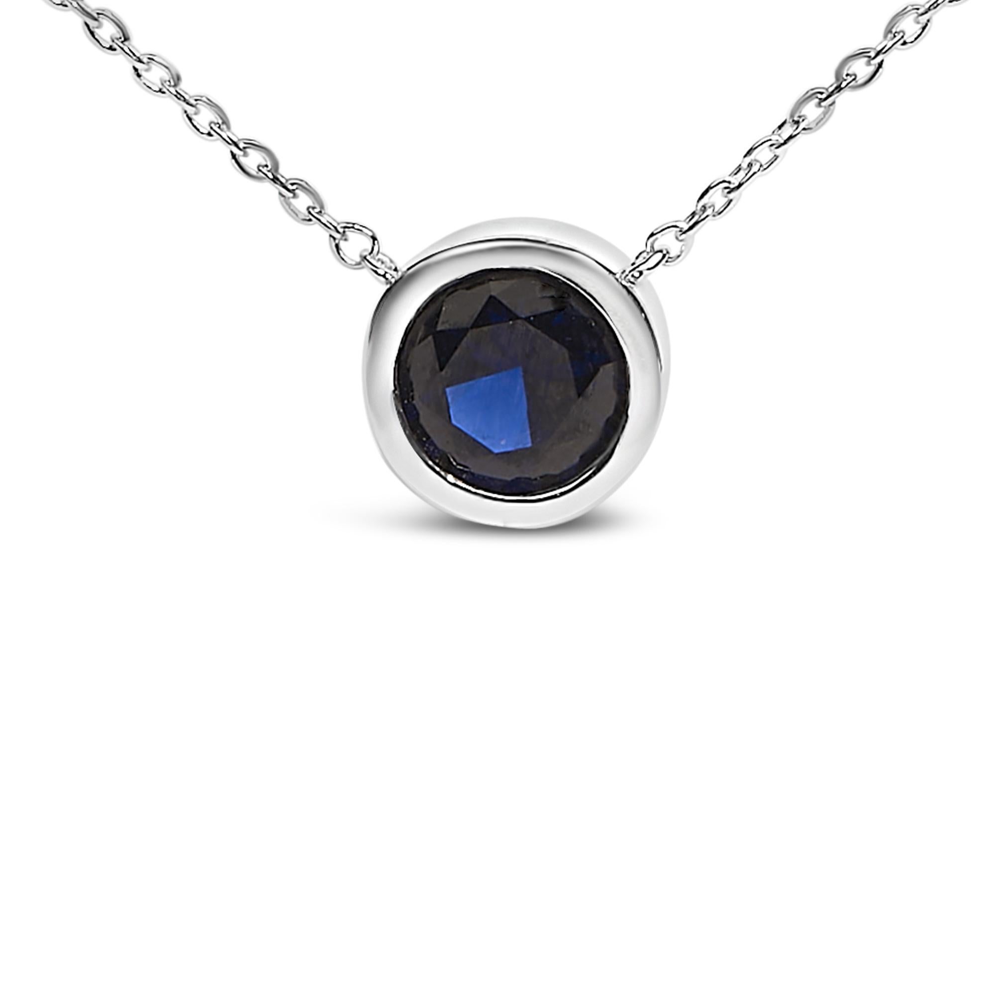 D'un éclat captivant, ce collier pendentif exquis allie l'allure intemporelle de l'argent sterling .925 à la sophistication moderne d'un saphir bleu créé en laboratoire et serti d'un chaton. Façonné de main de maître, le pendentif brille de tous ses