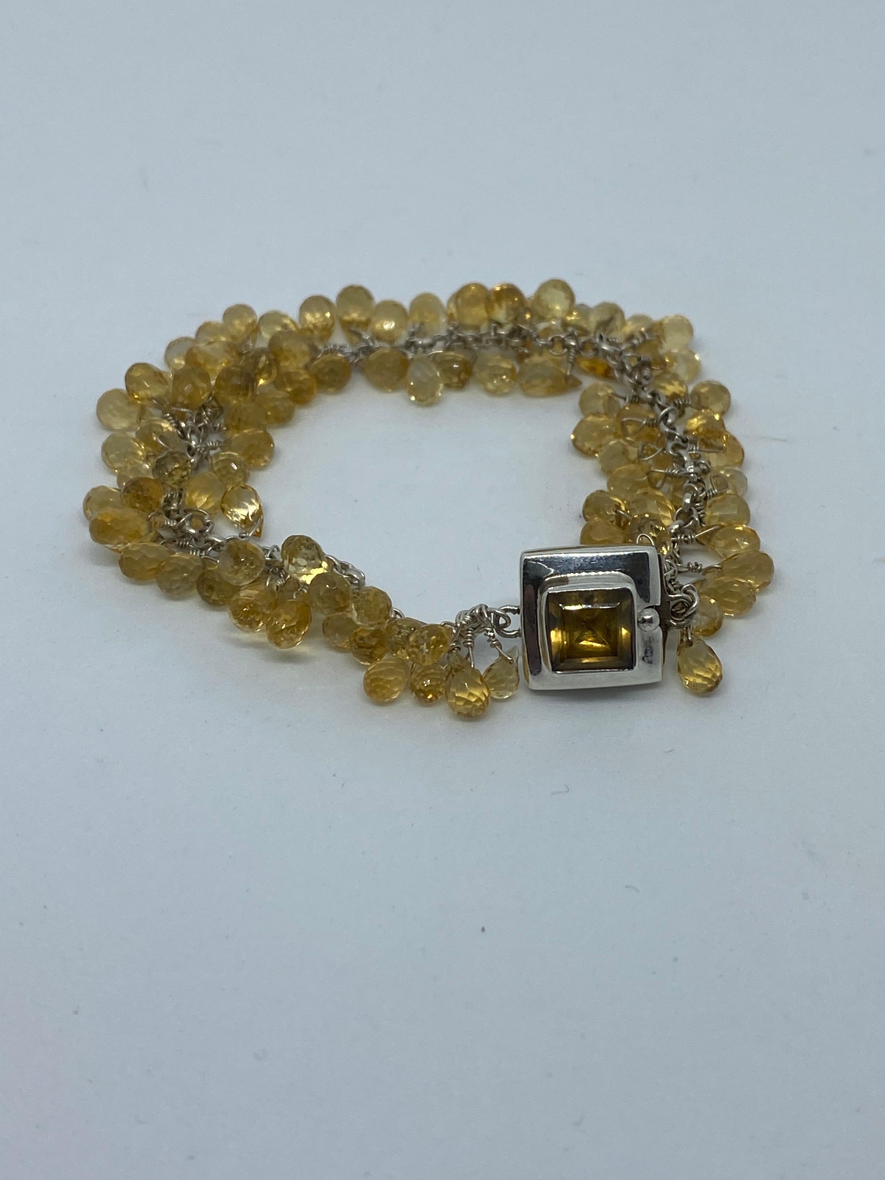 This bracelet features citrine briolettes that are hand wore wrapped in sterling Silver and dangle on the wrist. It shimmers and shines and makes a statement of elegance. All in yellow tones the clasp features a bezel-set Square 7mm Citrine.