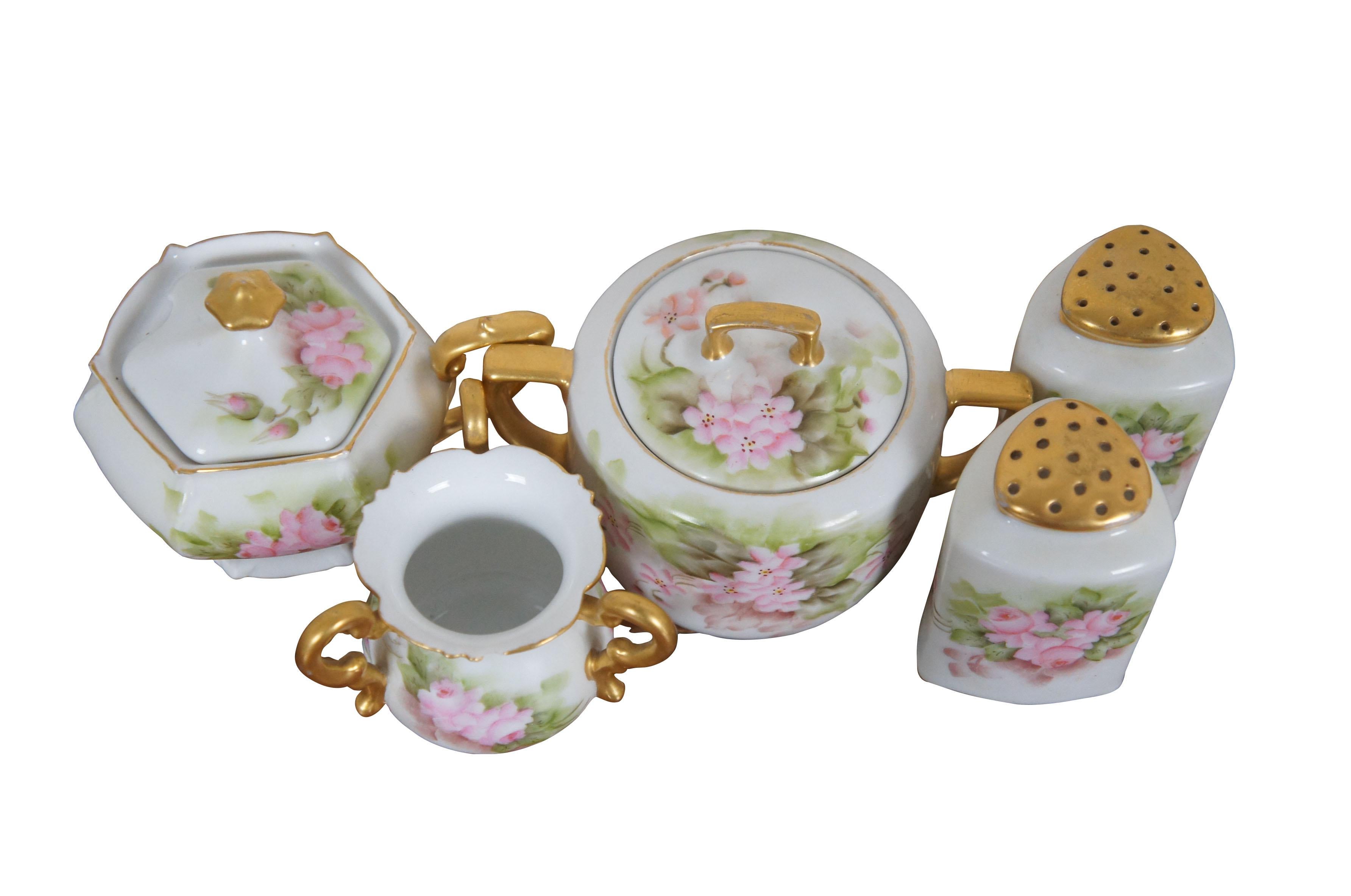 Late 19th - early 20th century.  Neat set of assorted tableware pieces, all decorated with hand painted pink flowers, green leaves, and gilded accents by F. Foljan. Double handled sugar bowl with lid by MZ Austria, incised number 1190/S (Mark used