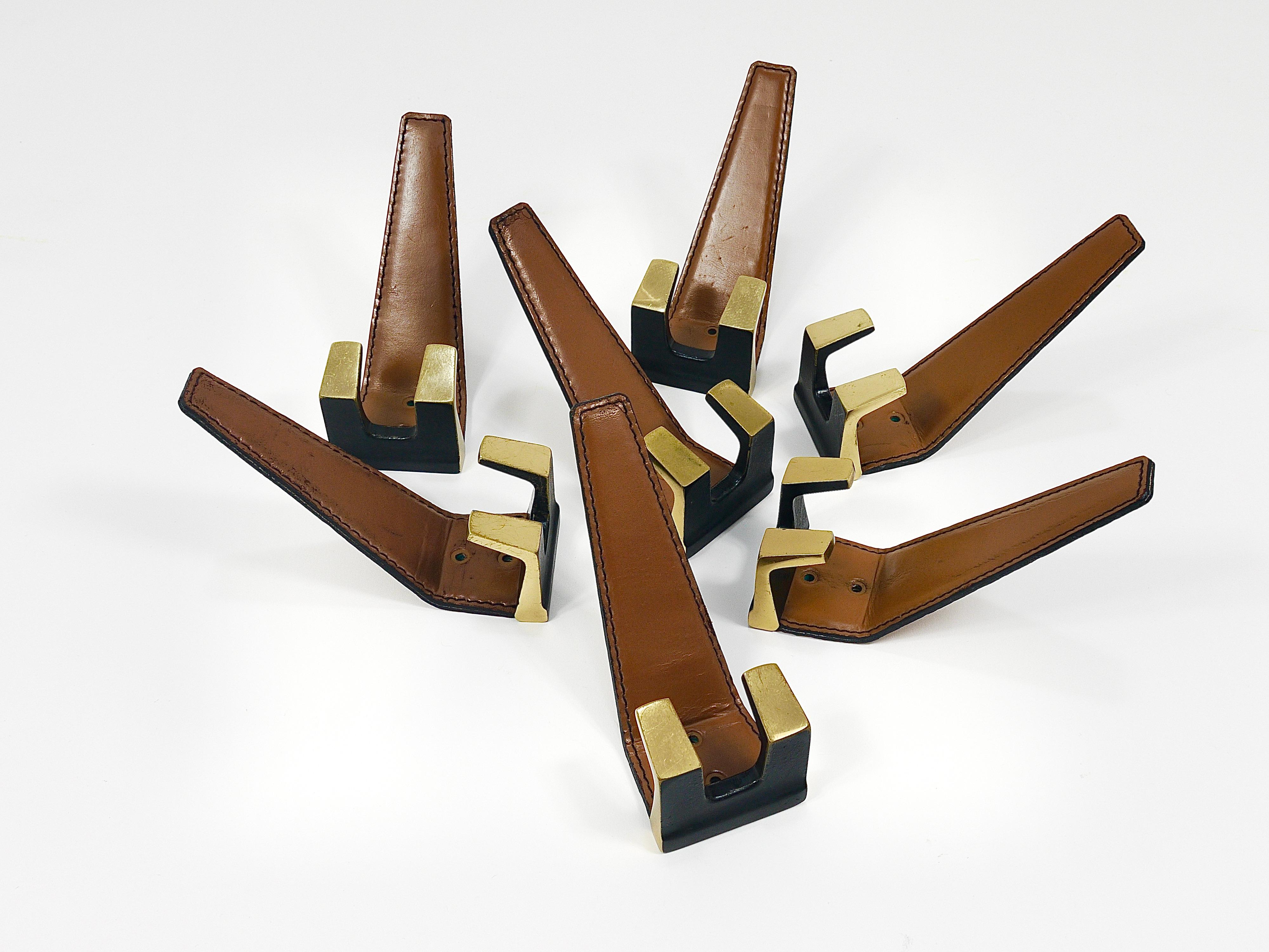 Up to six beautiful vintage Modernist wall coat hooks. Sold individually and priced per piece. Crafted in Vienna, Austria during the 1950s, these hooks are made of solid brass, partly black patinated and partly polished, and adorned with medium