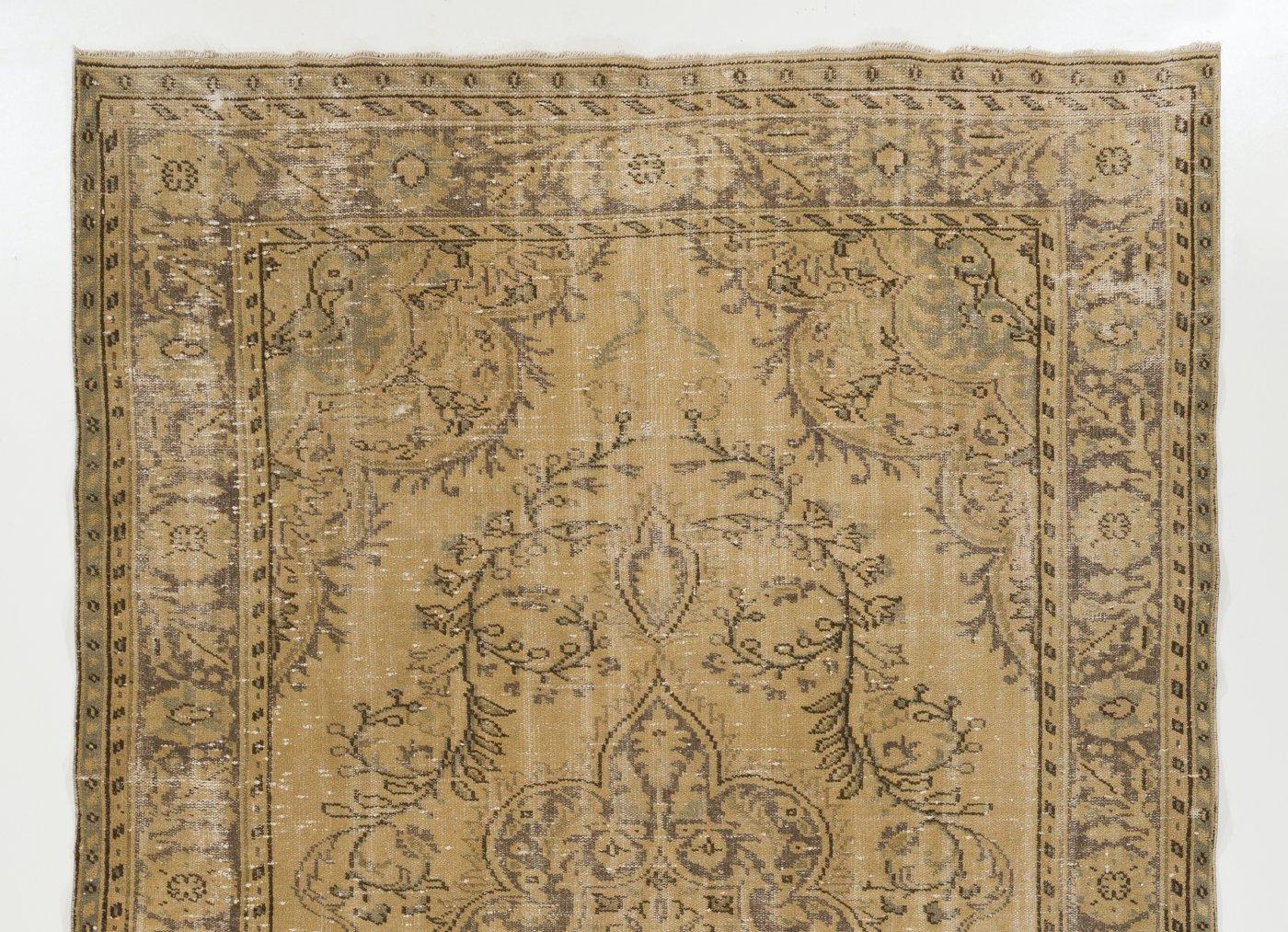 A finely hand-knotted vintage distressed Turkish carpet from 1960s featuring an elegant medallion design. The rug has even low wool pile on cotton foundation. It is heavy and lays flat on the floor, in very good condition with no issues. It has been