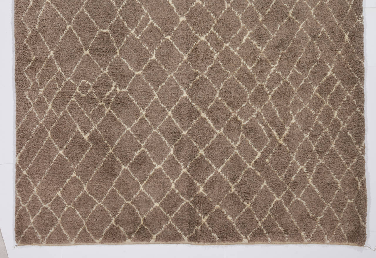 A contemporary hand-knotted Moroccan rug with soft cozy pile, made of natural undyed ivory/cream and light brown wool. 
Available as it is or made to measure in any size and color combination requested. Measure: 7x10.4 Ft.