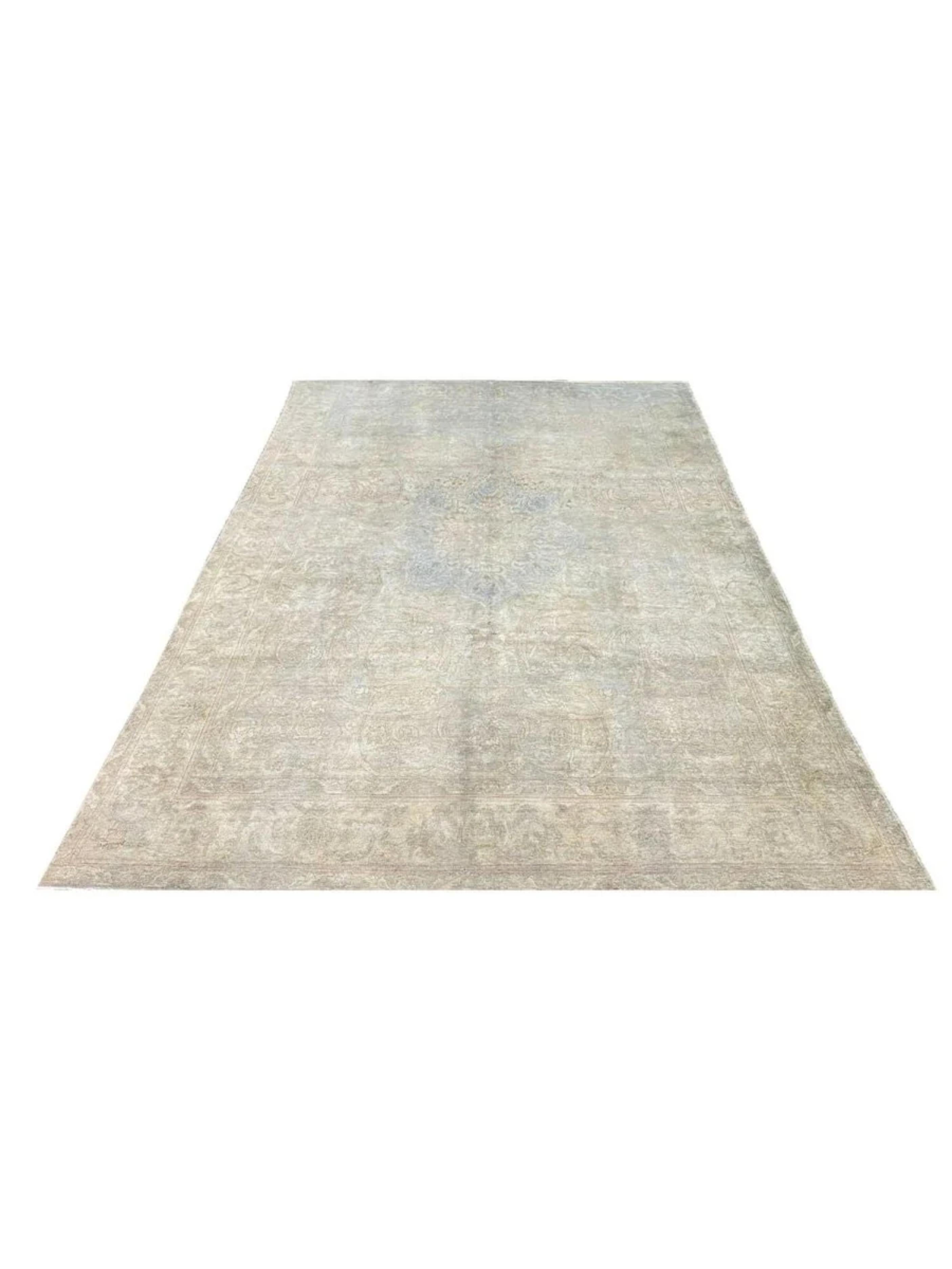 This one-of-a-kind antique Tabriz rug features a beautifully faded design in soft beige tones, complemented by delicate hints of gray and subtle touches of blue. These gentle variations in color lend the rug an elegant depth while preserving the