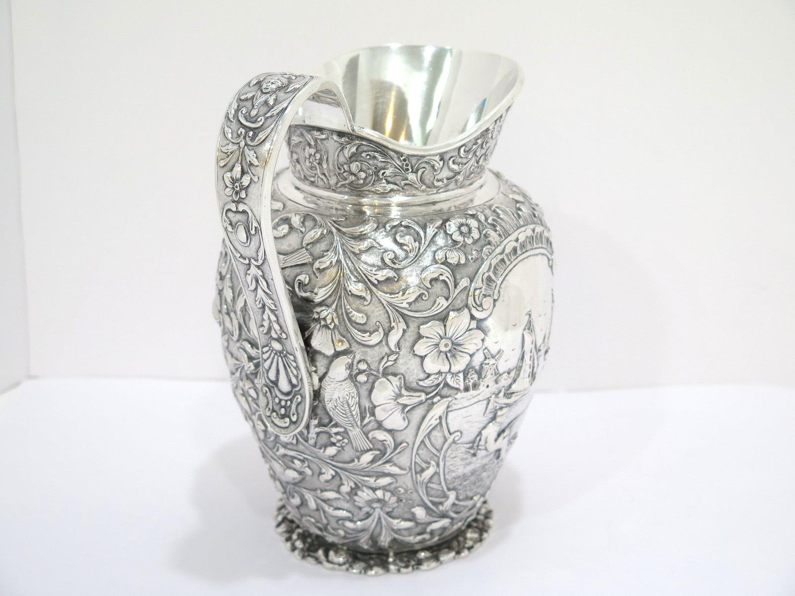 8 7/8 in - European Silver Antique Dutch Scenery Flowers Birds Repousse Pitcher In Good Condition For Sale In Brooklyn, NY