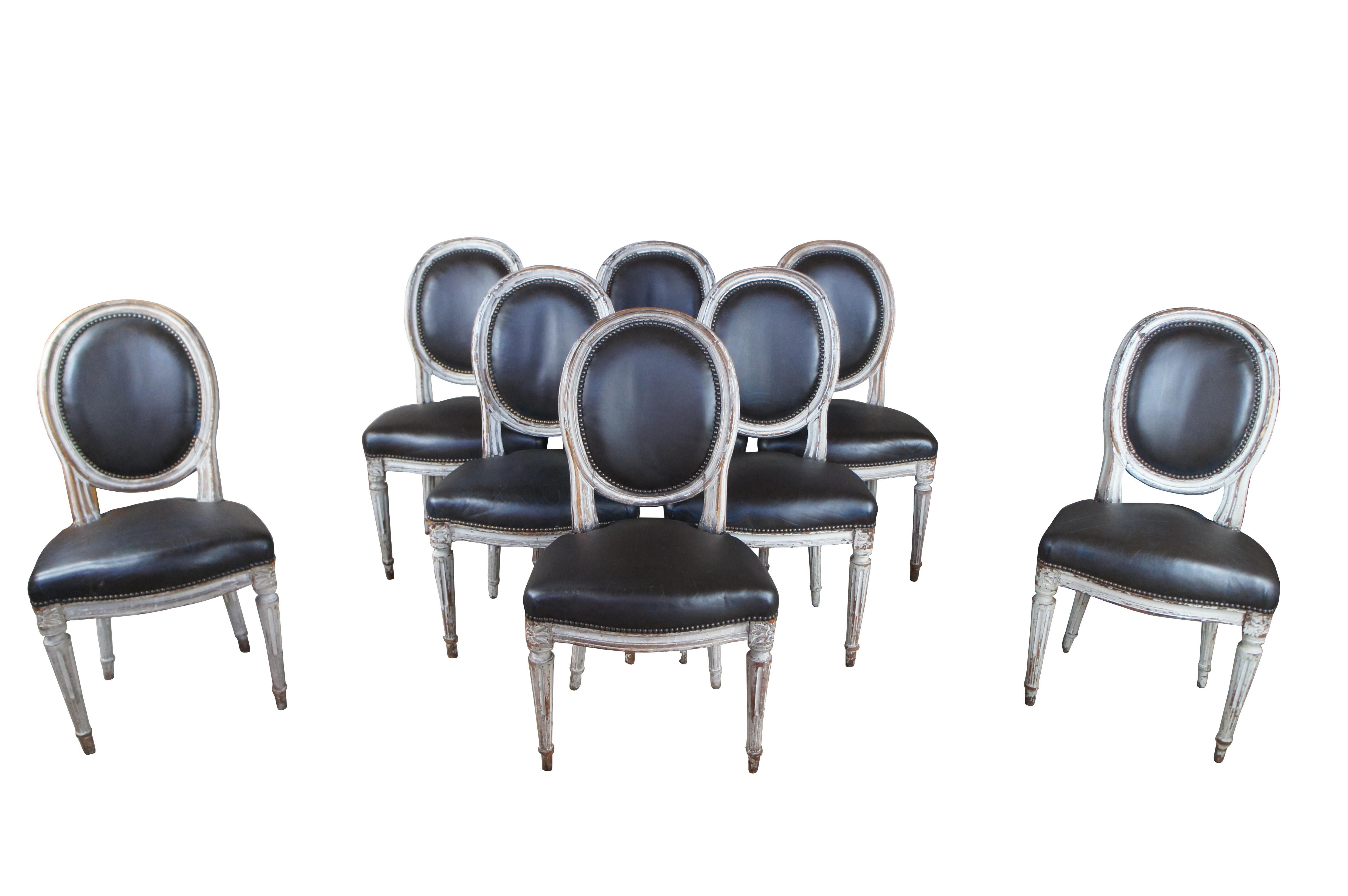 Exceptional set of 8 antique French Louis XVI Dining Chairs, circa mid-19th century.  Features iconic styling with a hardwood frame painted in white, with brown leather upholstered seat and back.  The finish has a rich patina from years of use,