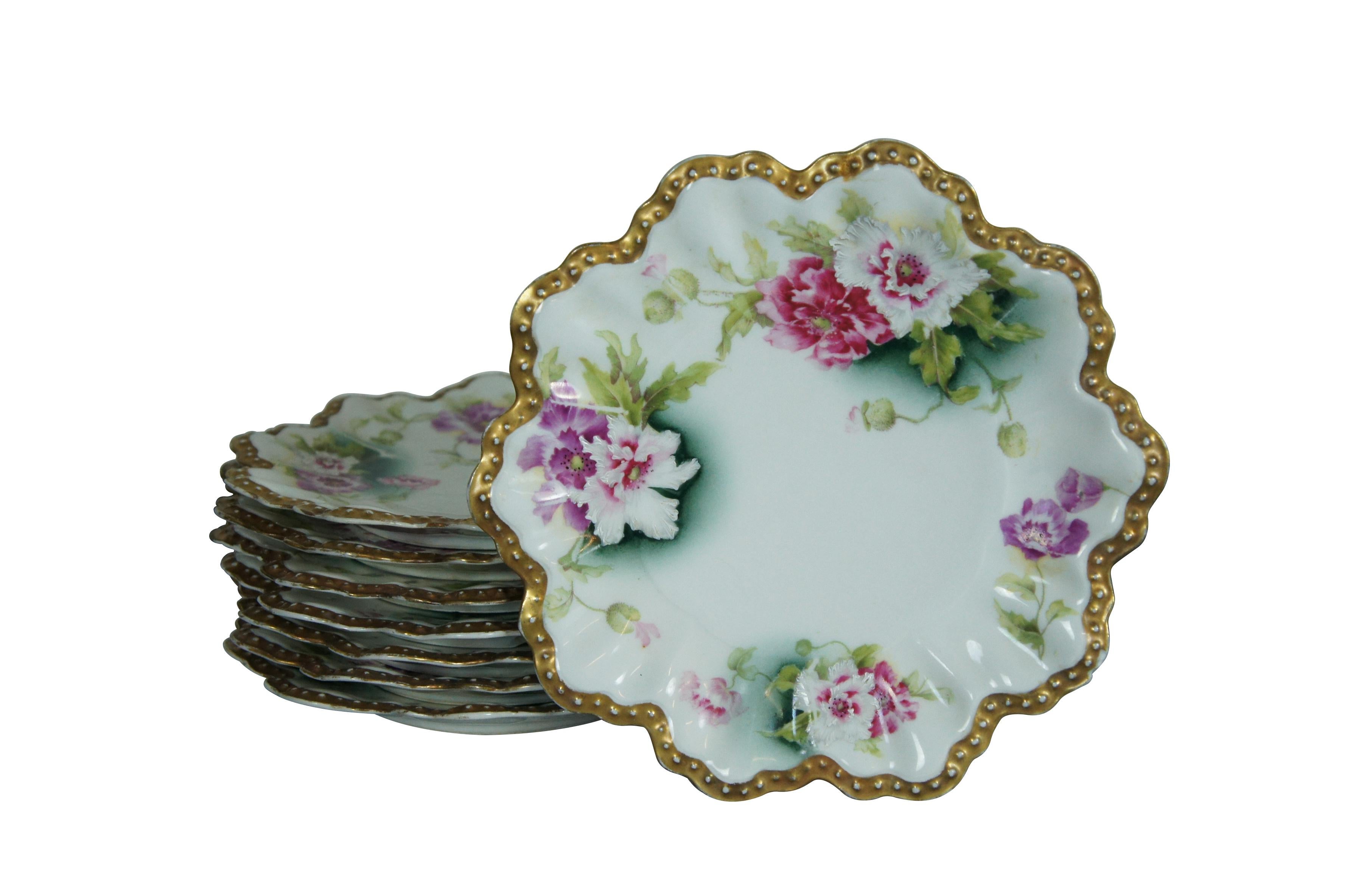 Juego de 8 platos de porcelana de Limoges de A. Lanternier & Co de finales del siglo XIX-principios del XX con bordes profundamente festoneados y dorados que parecen pétalos de flores, haciendo eco del motivo floral verde, rosa y morado. Marca