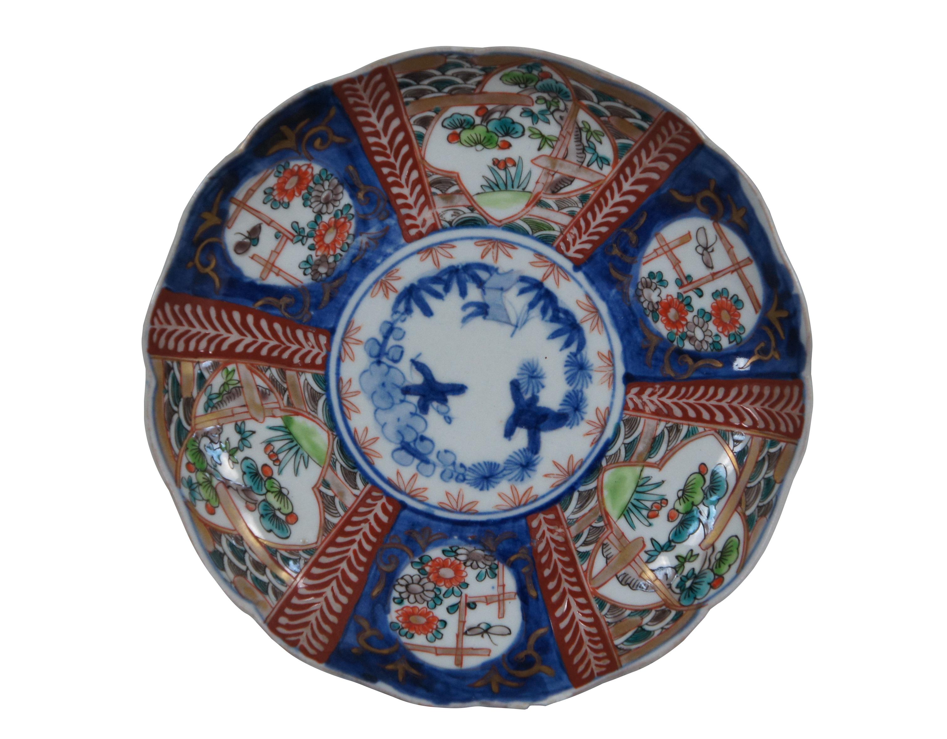 Ensemble de 8 assiettes à salade / assiettes plates en porcelaine japonaise imari du début du 20e siècle, à bords festonnés, peintes à la main de panneaux de paysages et de fleurs en forme d'éventail, entourés de motifs en bleu et rouge.

Dimensions