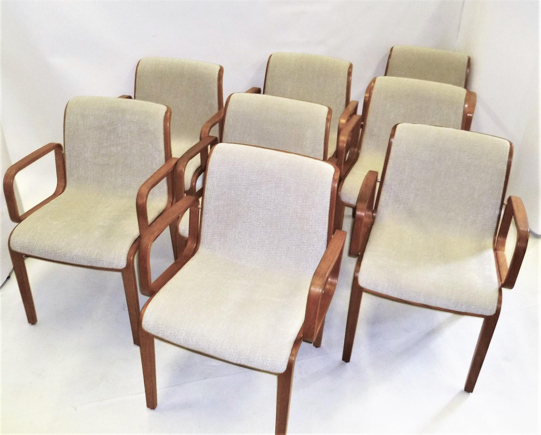 Designed in the mid-1960s by Bill Stephens (1932-2007) for Knoll, these eight midcentury armed dining chairs in blond oak have been newly reupholstered with a neutral soft ribbed bouclé fabric. Produced in the early 1970s, most have remnants of