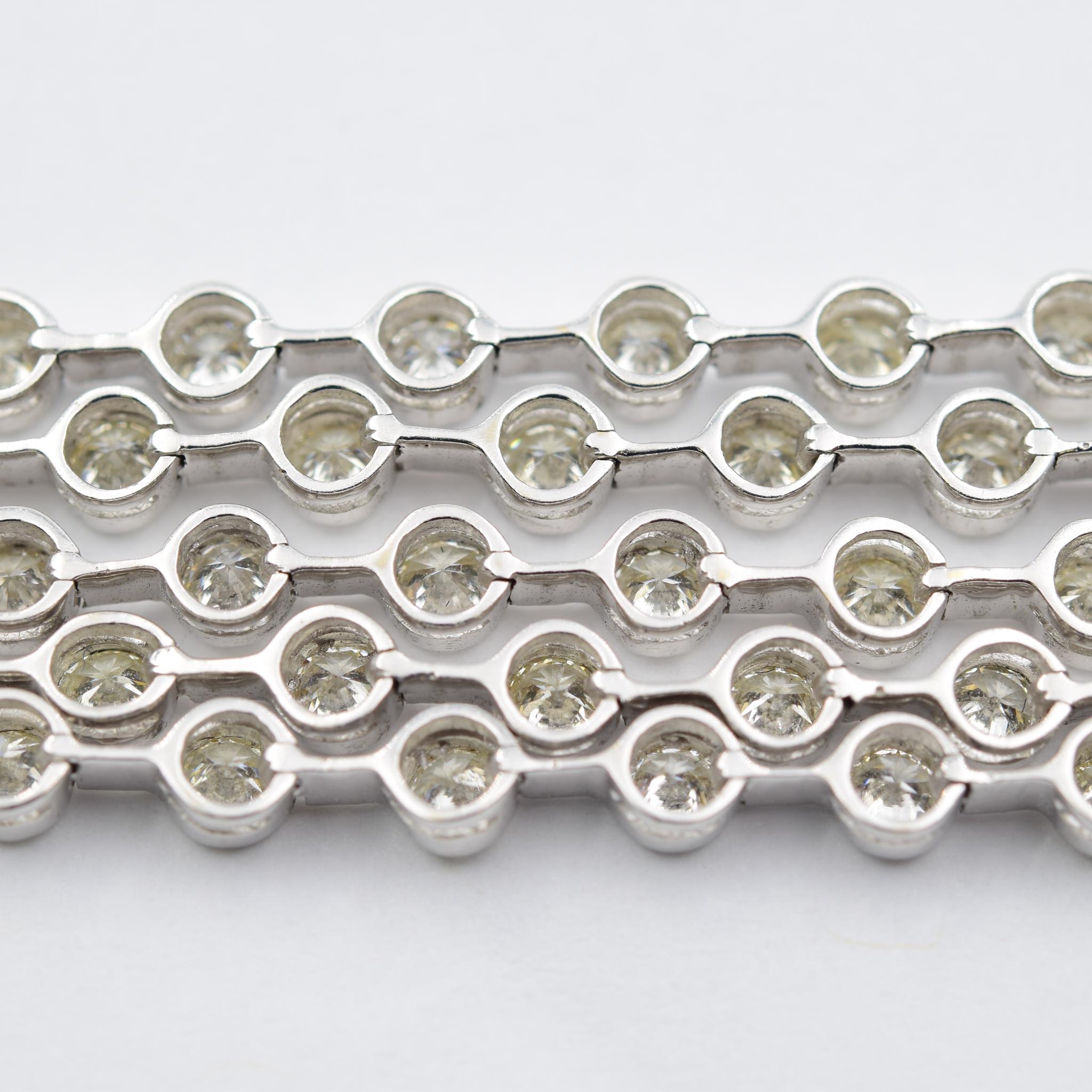 This vintage bracelet contains approximately 8.00 carats of diamonds. These diamonds are bezel set in 5 rows of high-quality white diamonds. It was crafted in 18k white gold. This bracelet has a unique twist on the typical diamond bracelet. Because