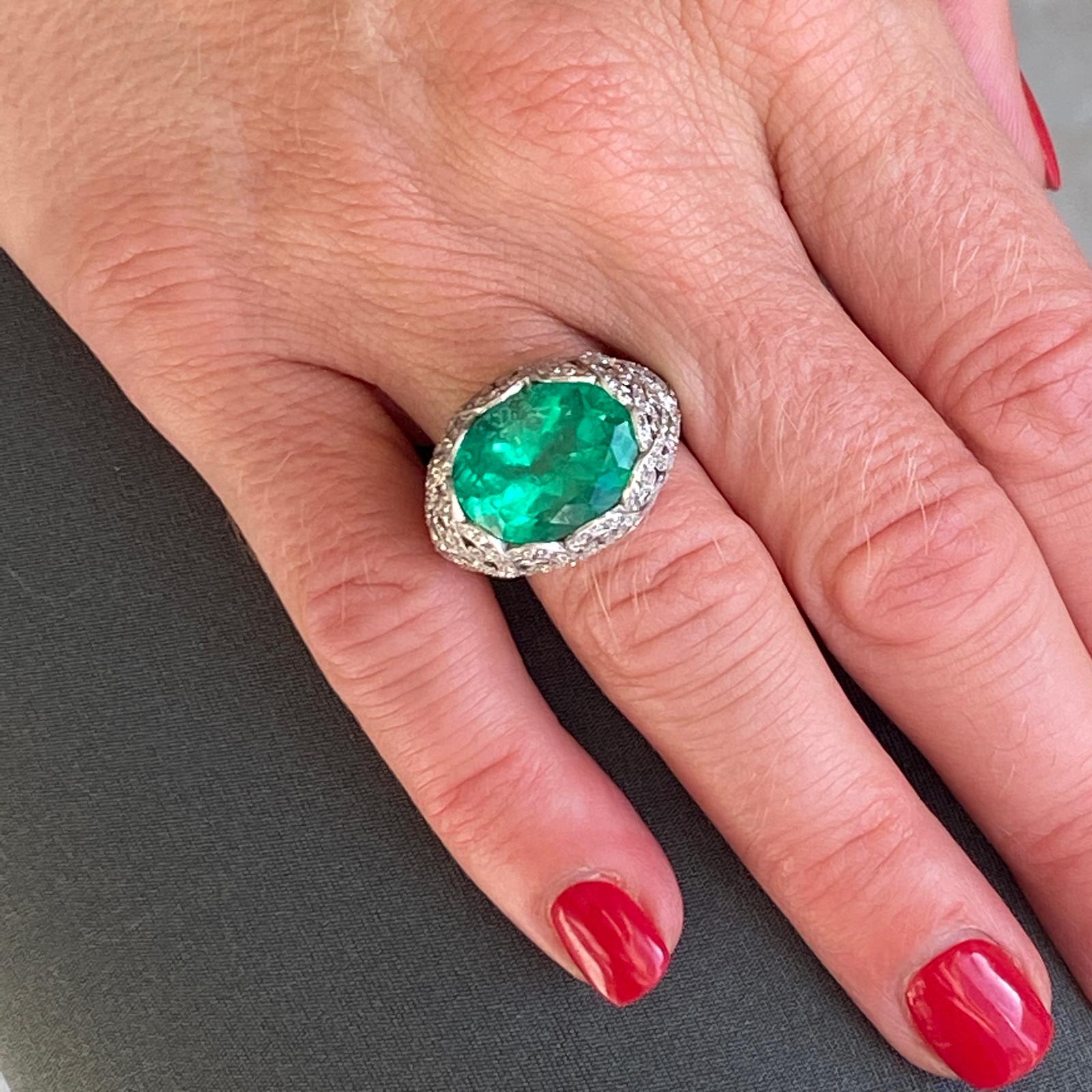 Stunning emerald diamond cocktail ring fashioned in platinum. The 8.18 carat oval Columbian Emerald is certified by the AGL (certificate included in the photos). The emerald is set in an Art Deco inspired mounting featuing Old European and rose cut