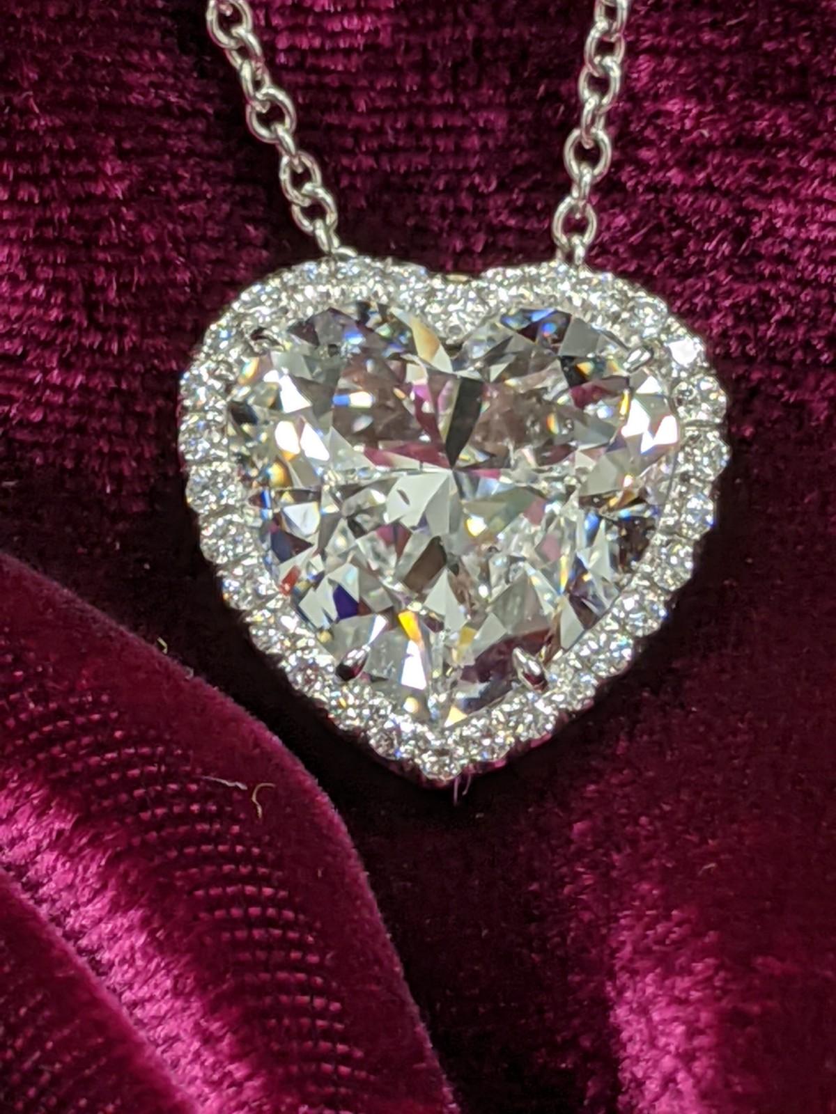 8 ct. Heart Shape diamond is surrounded by a halo of 30 small round diamonds (0.30 ct).  Center diamond is GIA certified as an E color with SI-1 clarity, but you wouldn’t be able to see a speck of inclusions with the naked eye (GIA report upon