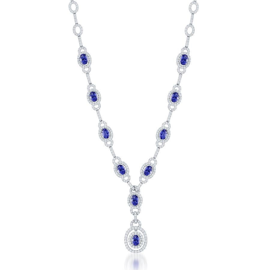 Este impresionante collar presenta un cautivador diseño que exhibe vibrantes zafiros azules de talla ovalada. La pieza está intrincadamente elaborada y acentuada por una combinación de brillantes diamantes redondos en un diseño calado, engastados en