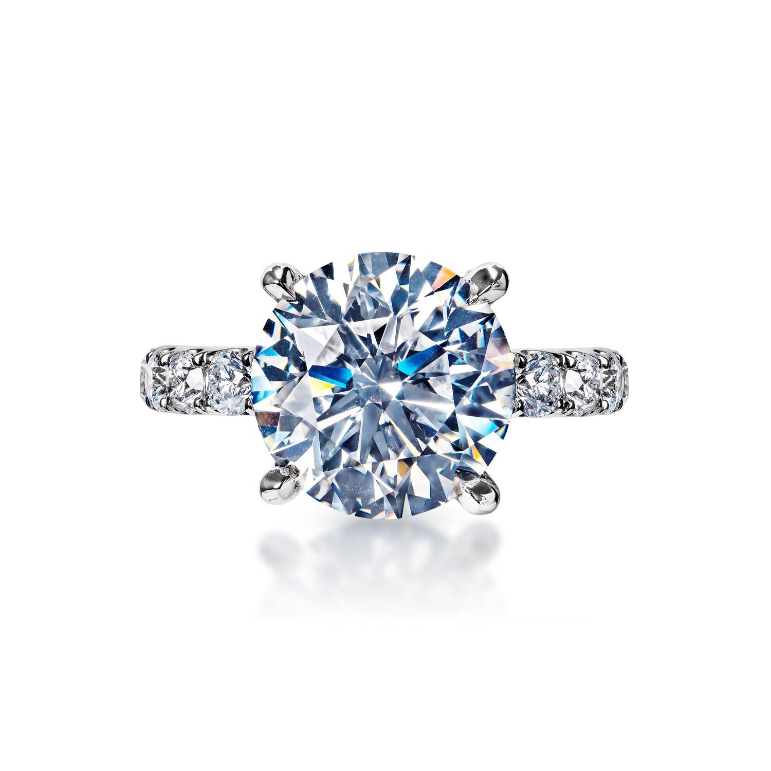 Earth Mined Center Diamond:
Carat Weight: 6.00 Carats
Color: E
Clarity: SI1
Style: Round Brilliant Cut

Carat Weight: 2.25 Carats
Shape: Round Brilliant Cut
Setting: 4 petite claw prong & shared prong
Metal: 18 Karat White Gold 7.60 grams

Total