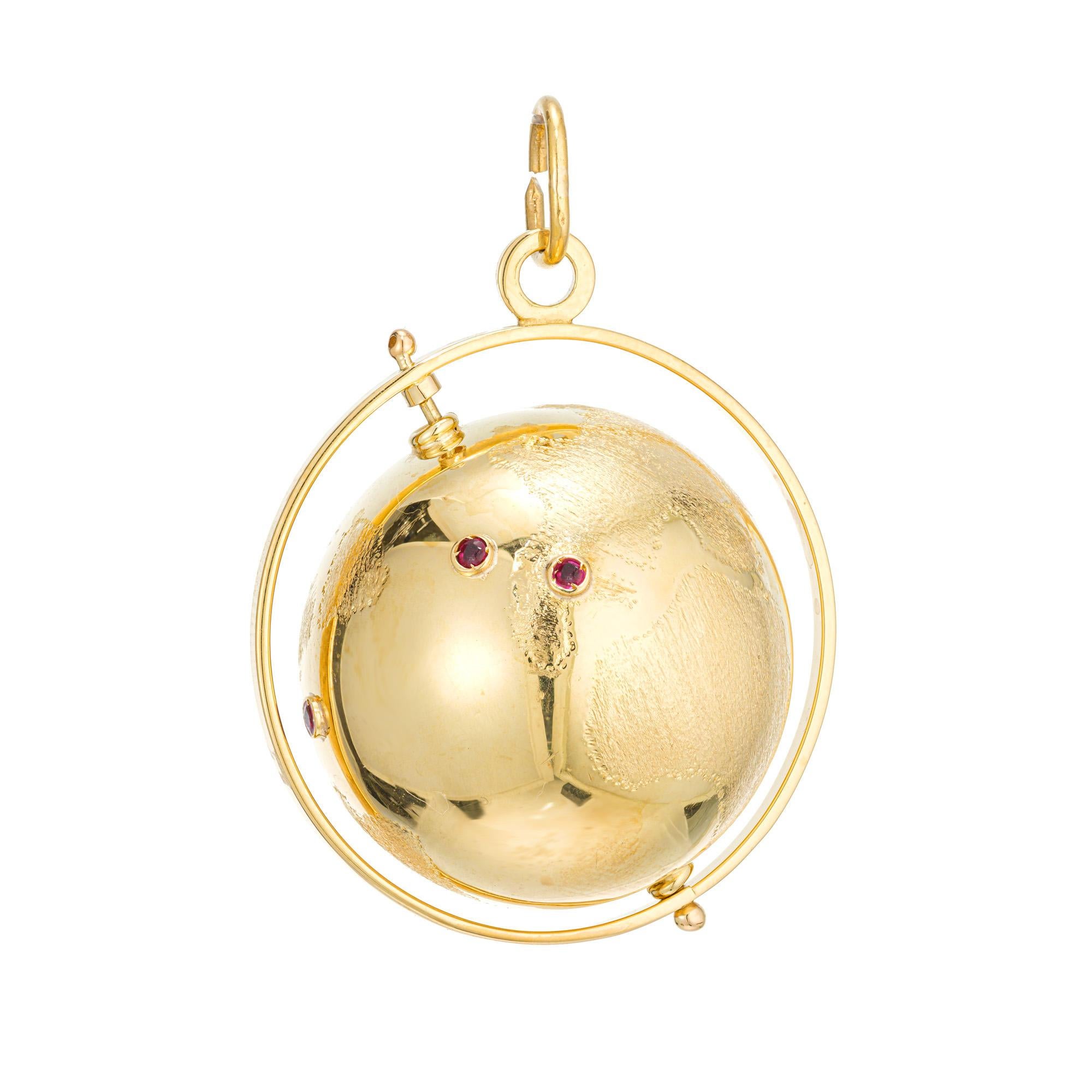 1960's Three Dimensional 18k Gelbgold Spinning Globe Charme mit gravierten Kontinenten und Rubin Akzente.

4 runde rote Rubine, ca. .8cts
18k Gelbgold 
Geprüft: 18k
9,7 Gramm
Von oben nach unten: 42,42 mm oder 1,61 Zoll
Breite: 30 mm oder 1,2