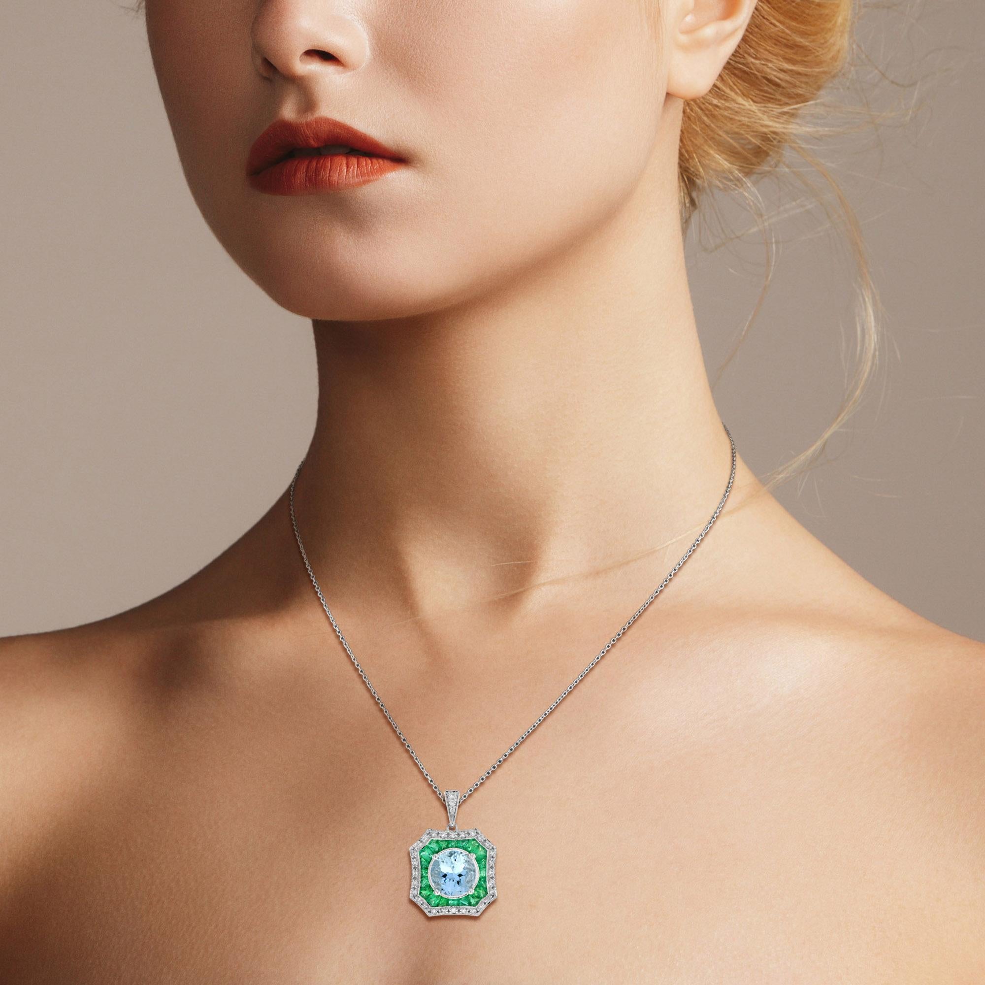 This elegant pendant is centrally set with a sparkly 8 carat aquamarine which is milgrain set. The aquamarine is then surrounded by a target of French cut vibrant green emeralds and glittering diamonds, similarly finished with a milgrain edges. The