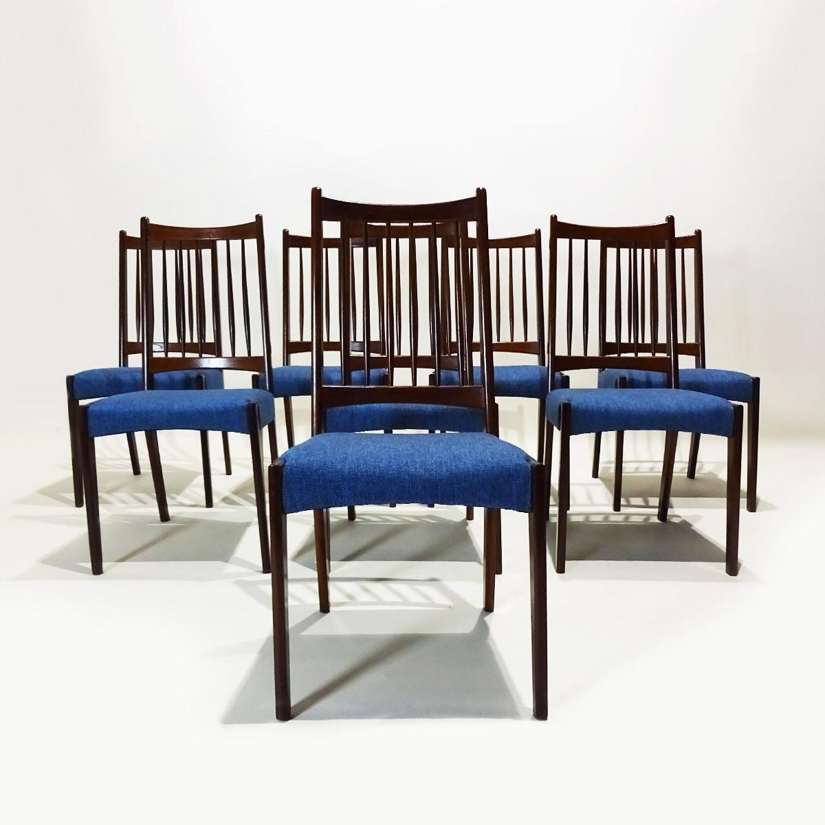 A set of eight mid century dark stained teak and fabric rail back dining chairs designed by Arne Hovmand Olsen and produced by Mogens Kold. 

These Olsen chairs are a classic design of his and were produced by Mogens Kold in the 1960s. These