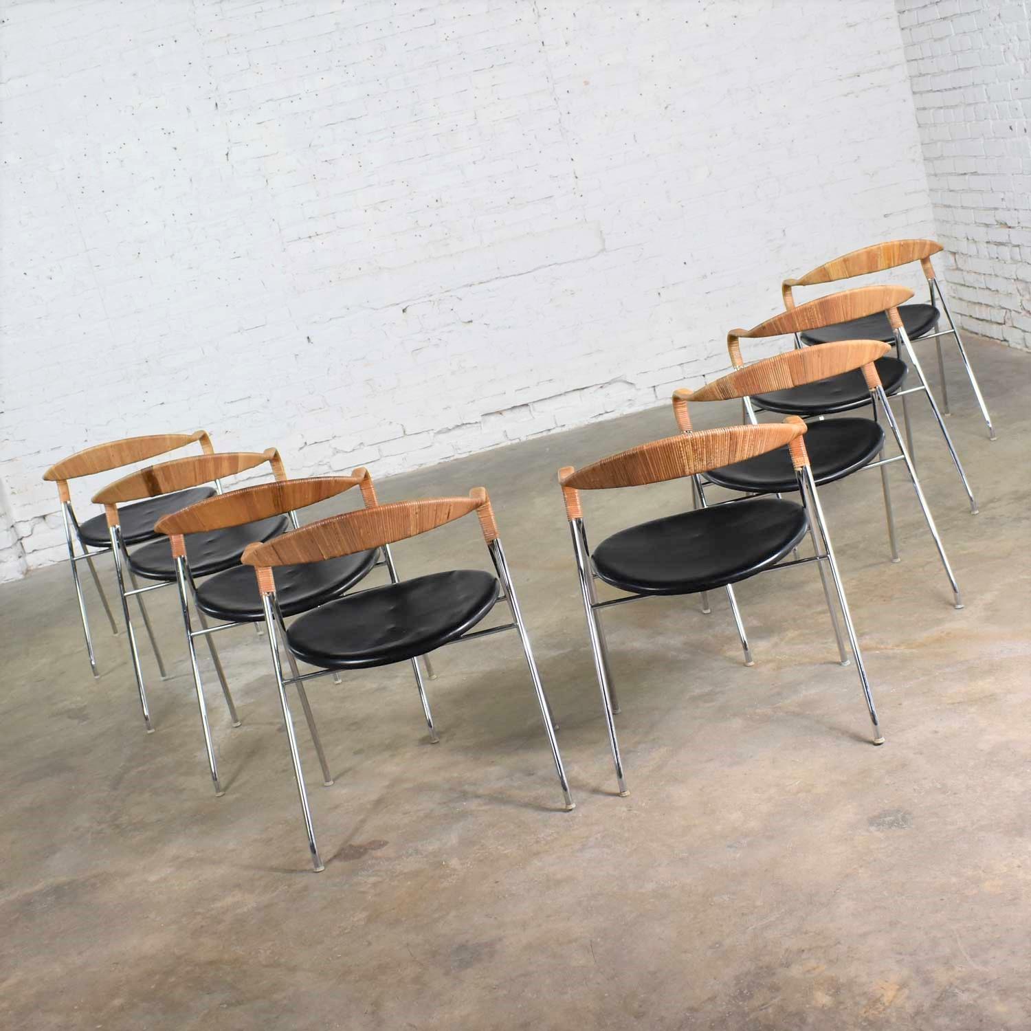 Incredible set of eight (8) Saffa chrome steel, wicker, and black vinyl faux leather dining chairs designed by Hans Eichenberger, produced by Dietiker, and distributed in the U.S. by Stendig. They are in wonderful original vintage condition. Some