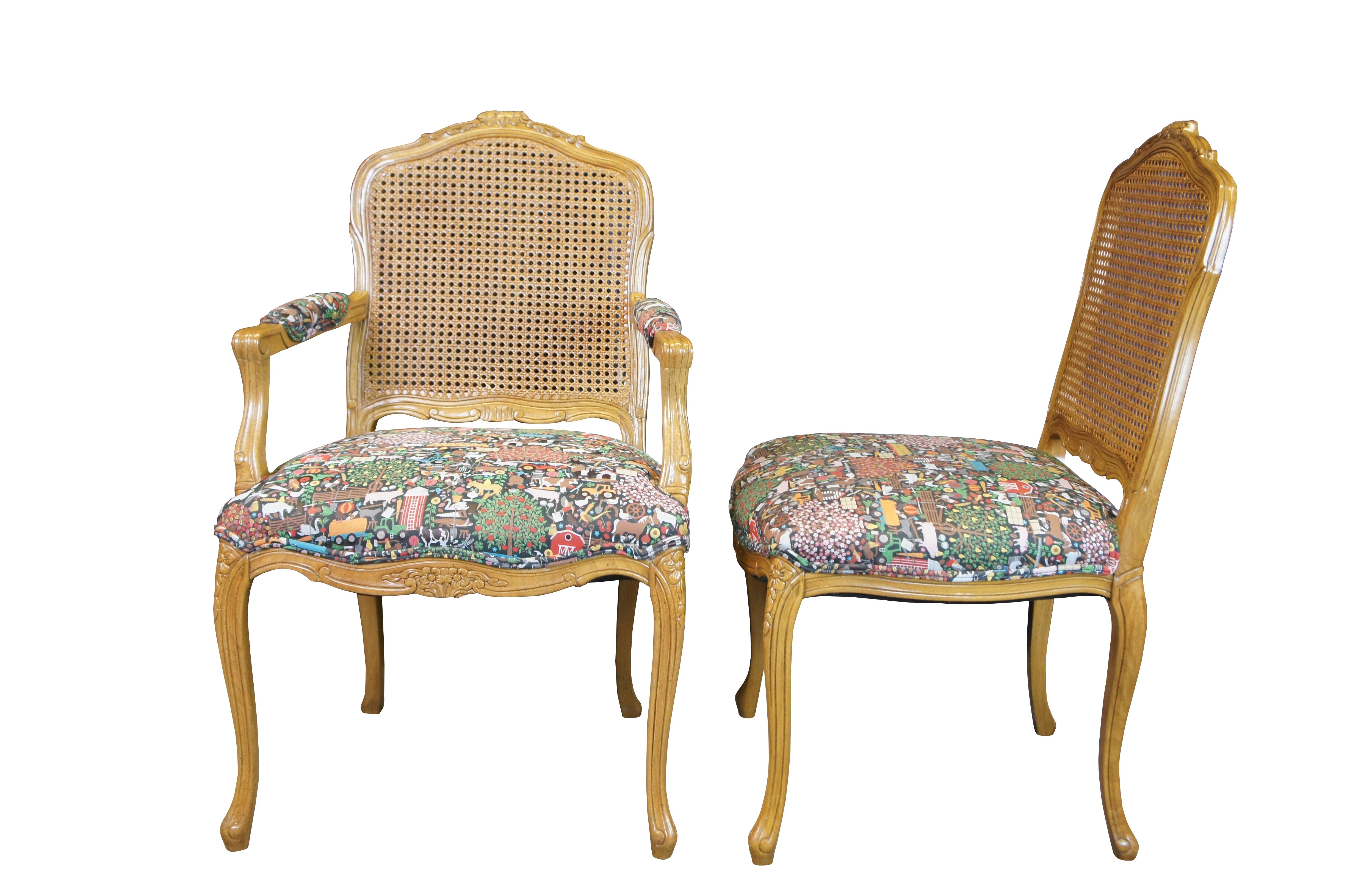 Eight vintage French Louis XV style dining chairs.  Made of walnut featuring caned backs with carved floral accents, fauteuil arms and whimsical country farmhouse scenes.  

Jacquard upholstery pattern called Bavaria #466162 by Studio Job (sold