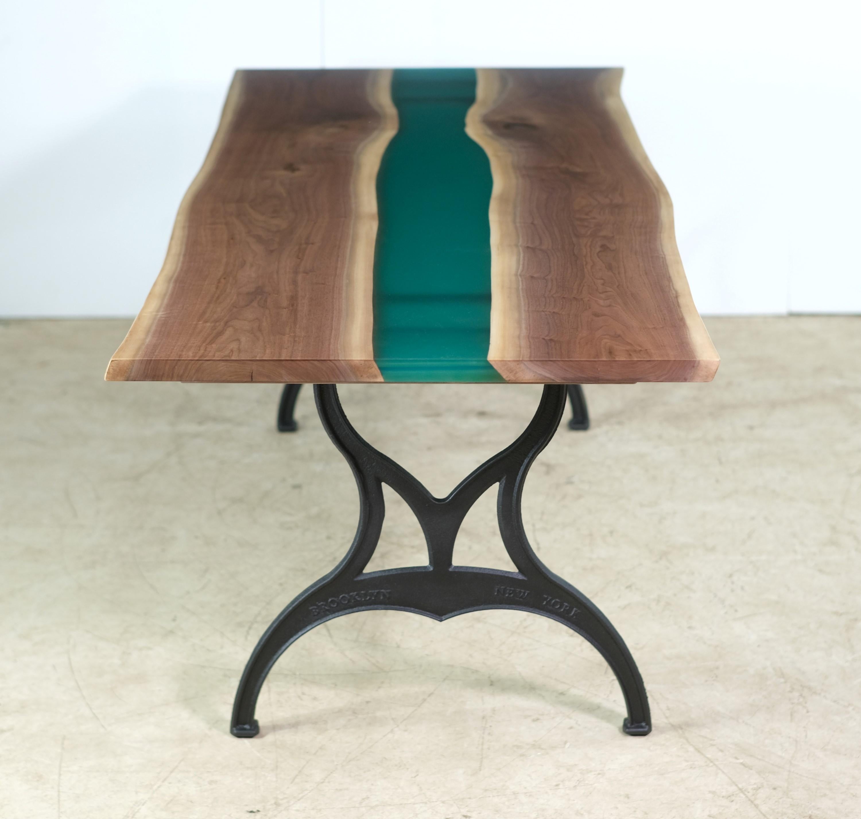 This table features a live edge two slab walnut top with a blueish green epoxy resin pour paired with Brooklyn New York cast iron legs. This table is ready to ship. Please note, this item is located in our Scranton, PA location.
