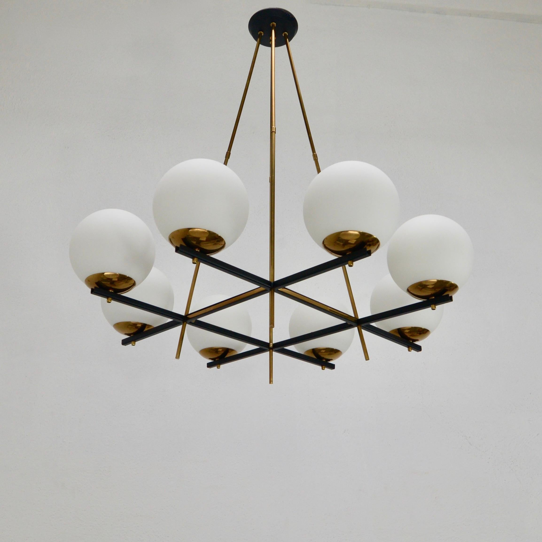 Stunning 8 globe classical midcentury 1950s Italian glass, steel, aluminum and naturally aged brass chandelier. Featuring an elegant grid pattern. With 1-E12 candelabra based sockets (1) per globe shade. Wired for use in the US. Light bulbs included