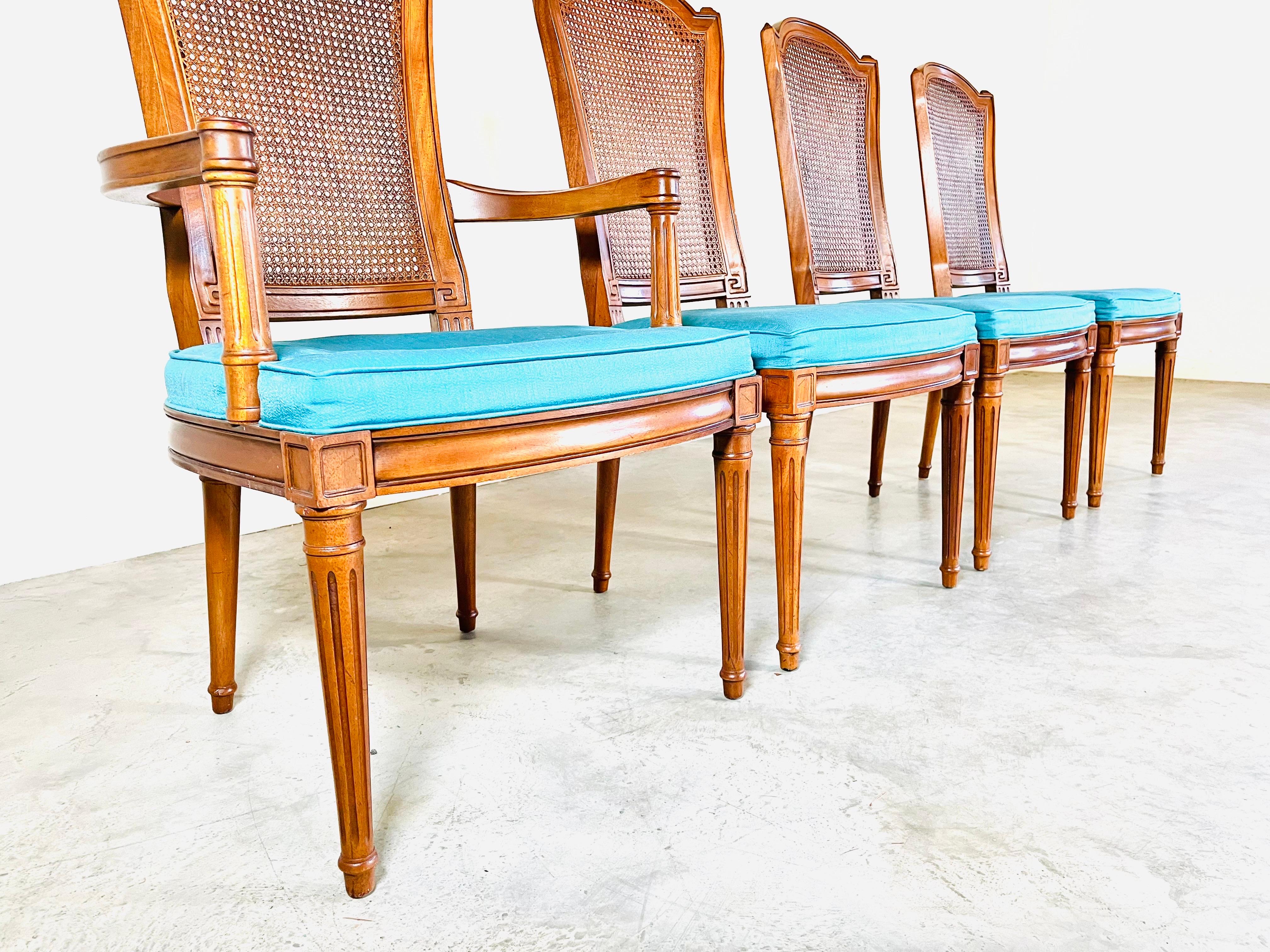 A beautiful set of 8 Louis XVI style cane back dining chairs having carved walnut frames by Henredon circa 1970. Stunning detail with solid frames throughout and cane that is strong and completely in tact with no damage. 
Original seat fabric needs